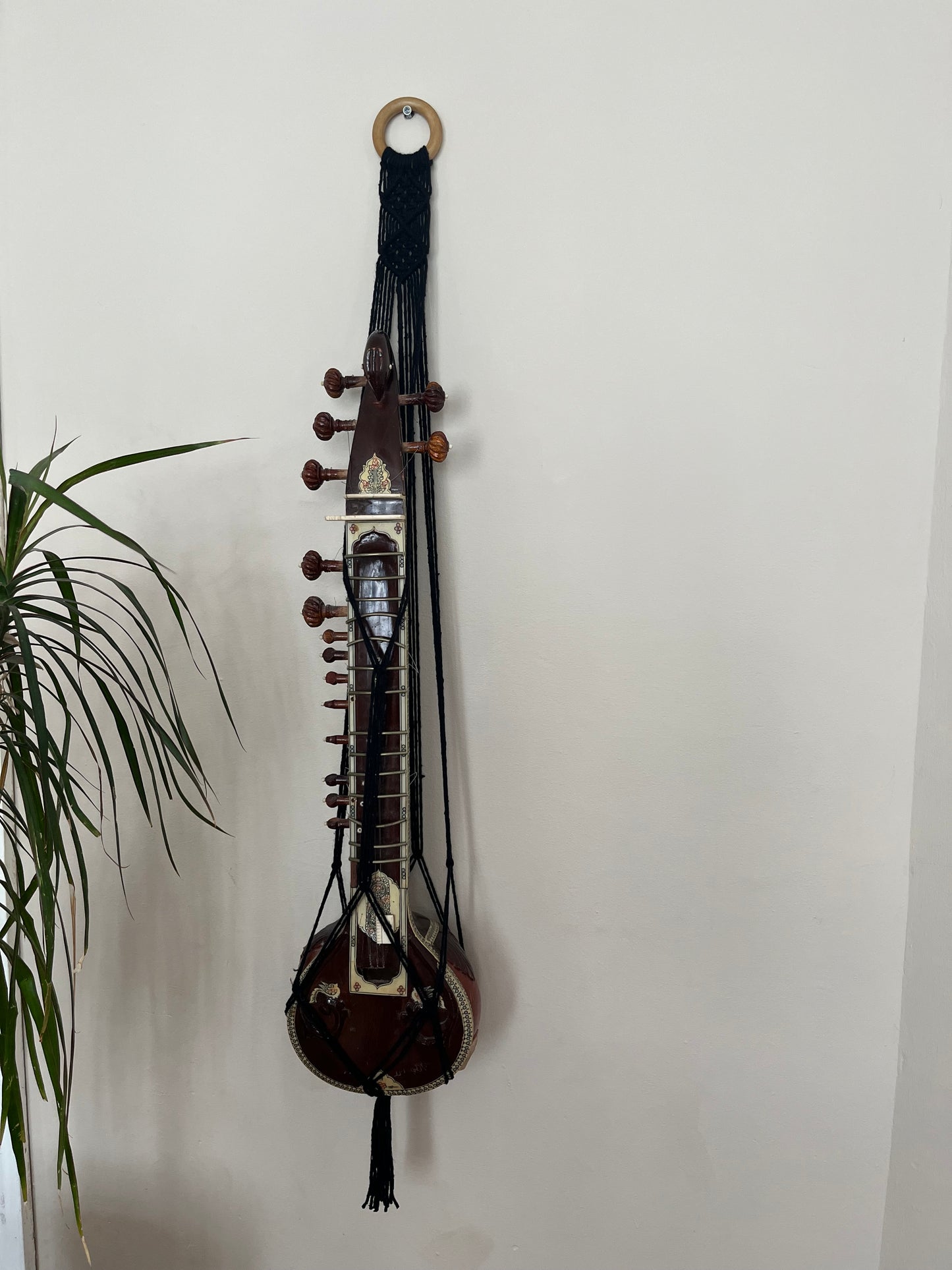 Mini sitar instrument wall hanger. Handmade using black recycled cotton on a repurposed wooden hanging ring.