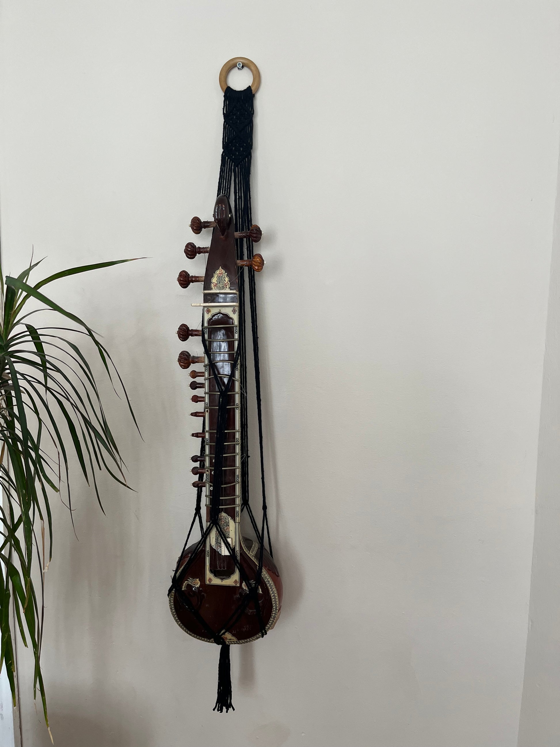Mini sitar instrument wall hanger. Handmade using black recycled cotton on a repurposed wooden hanging ring.