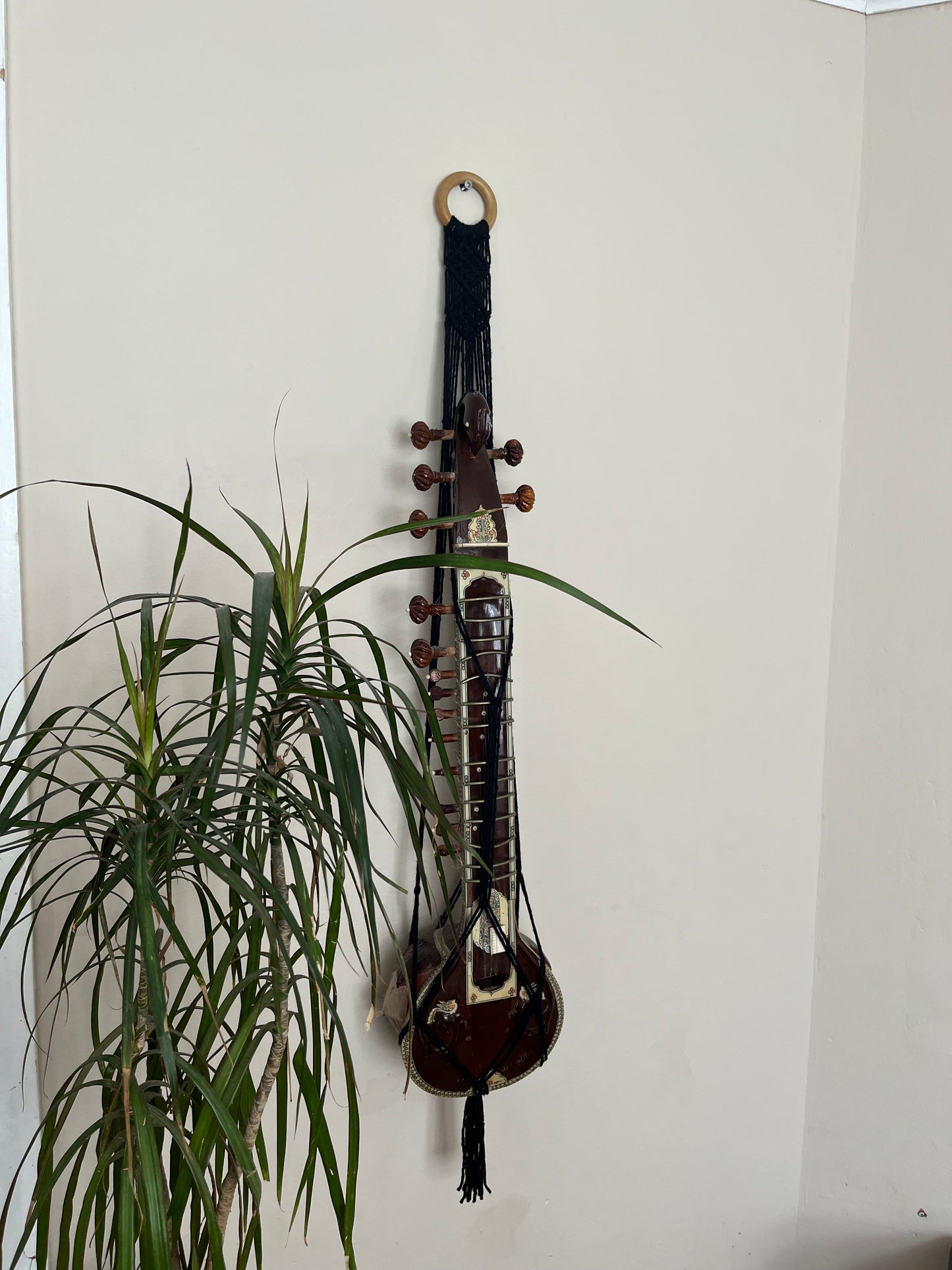 Mini sitar instrument wall hanger. Handmade using black recycled cotton on a repurposed wooden hanging ring.