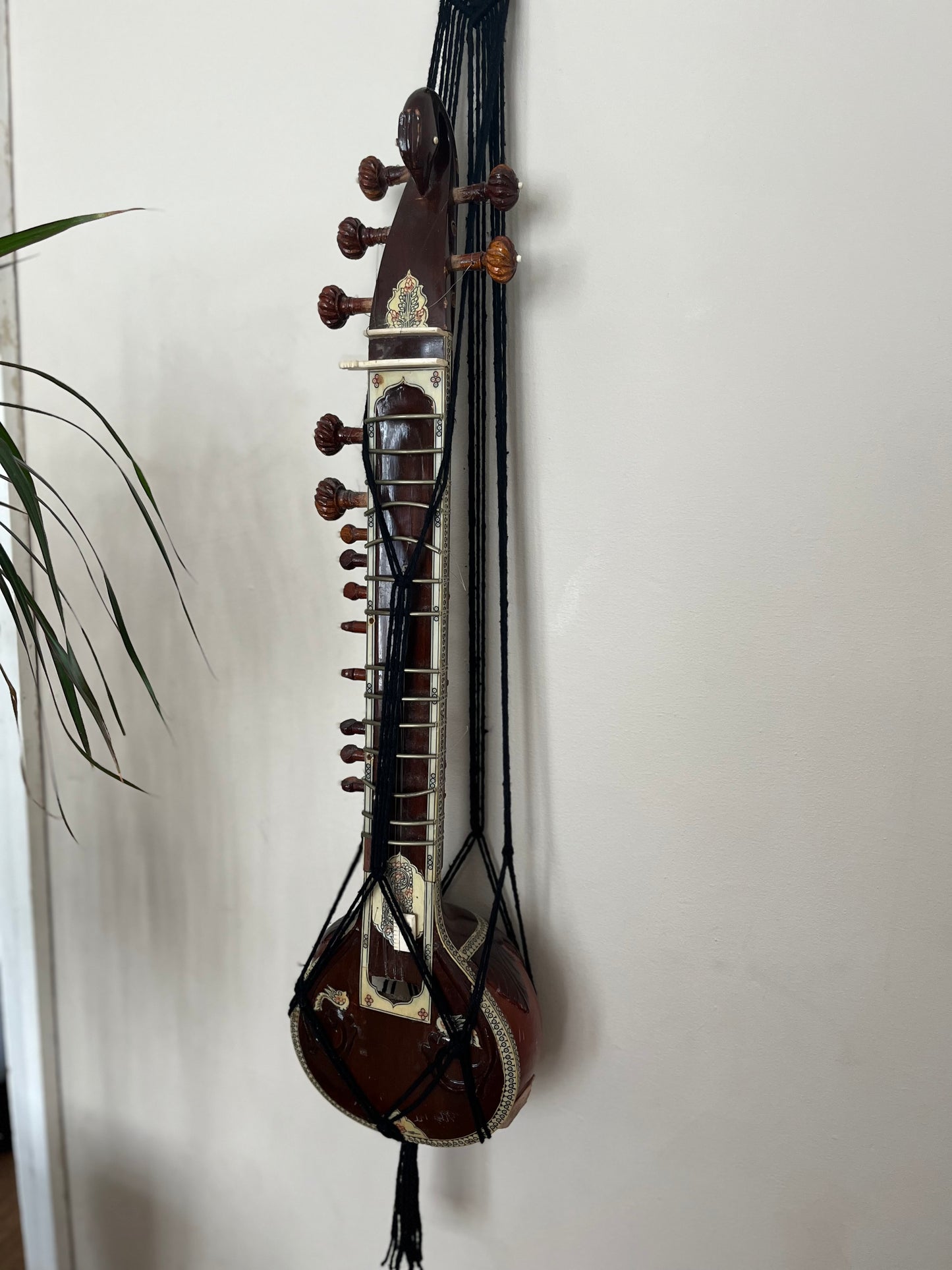 Mini sitar instrument wall hanger. Handmade using black recycled cotton on a repurposed wooden hanging ring.