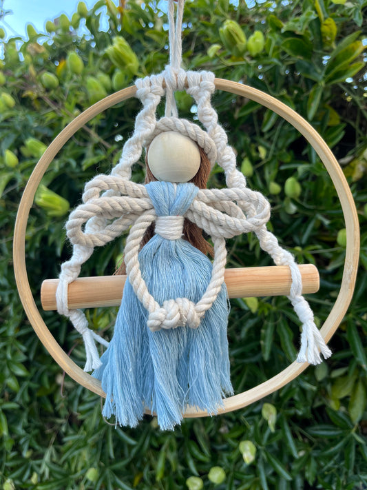 Macrame fairy on a wooden swing inside a wooden hoop, handmade using recycled cotton yarn.
