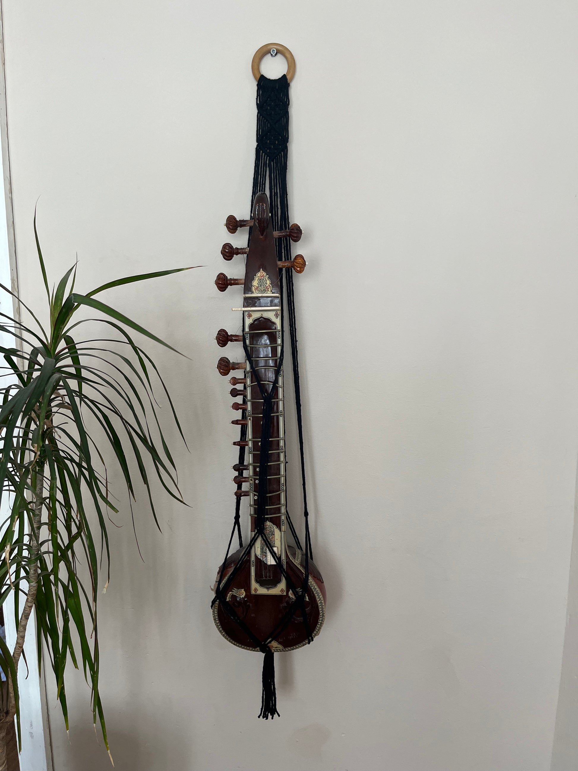 Mini sitar instrument wall hanger. Handmade using black recycled cotton on a repurposed wooden hanging ring.