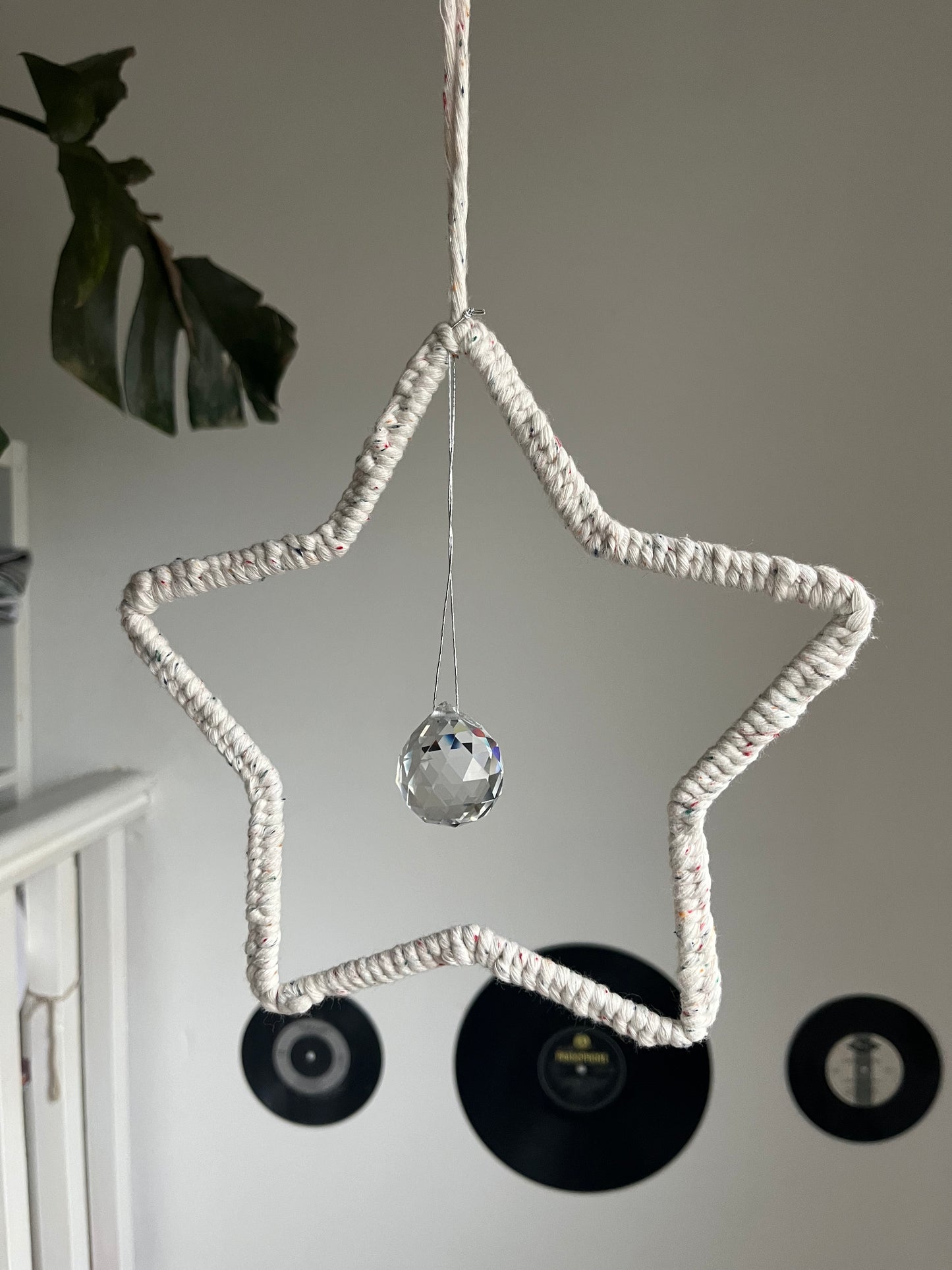 Star shaped macrame sun catcher hanging with a crystal prism. Made with recycled cotton yarn.