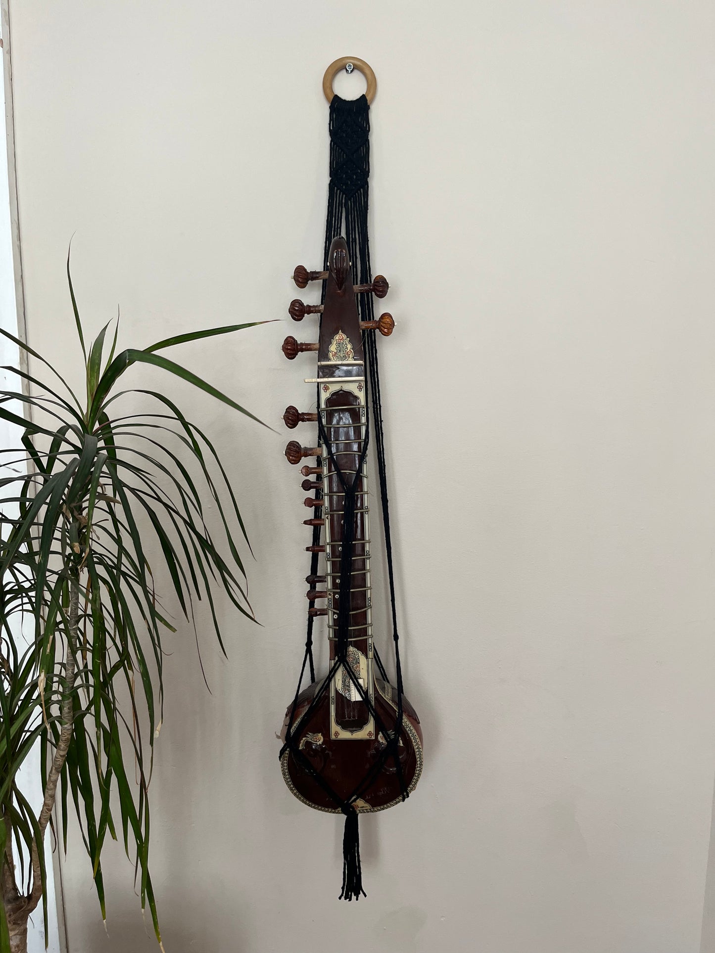 Mini sitar instrument wall hanger. Handmade using black recycled cotton on a repurposed wooden hanging ring.