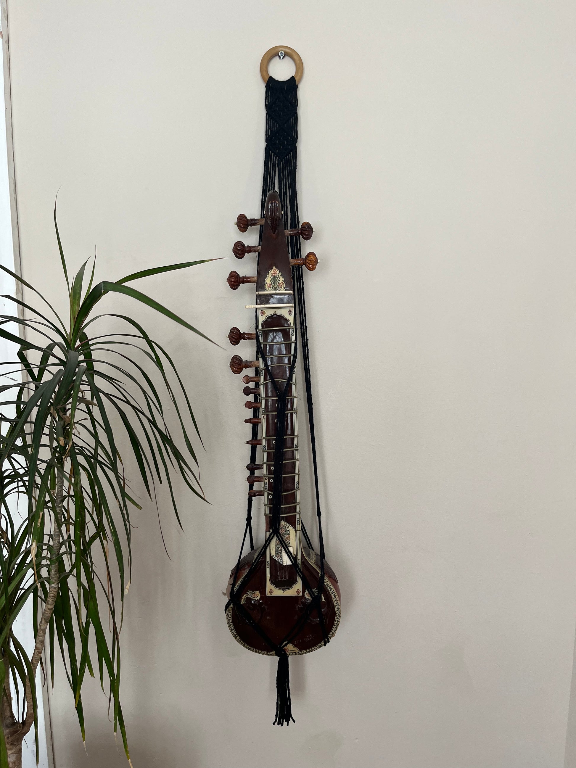 Mini sitar instrument wall hanger. Handmade using black recycled cotton on a repurposed wooden hanging ring.