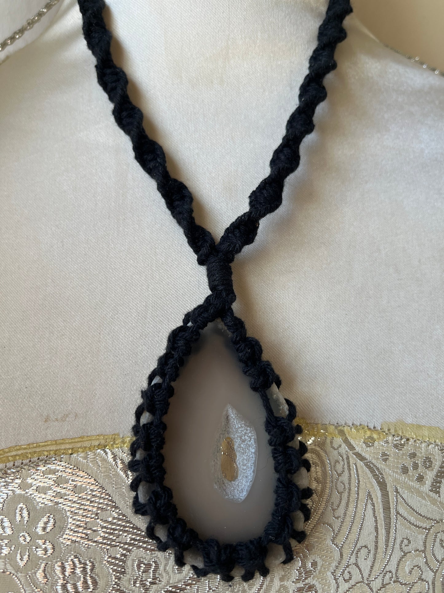 Close up image of Black necklace with natural agate slice on a mannequin