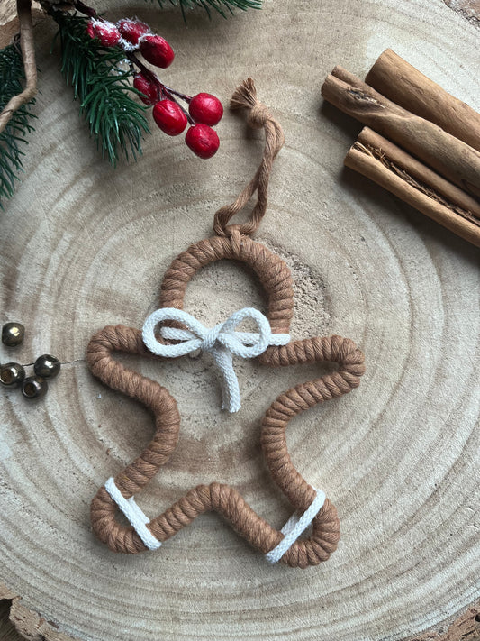 Gingerbread man shaped hanging tree ornament wrapped in brown recycled cotton yarn with white accents.