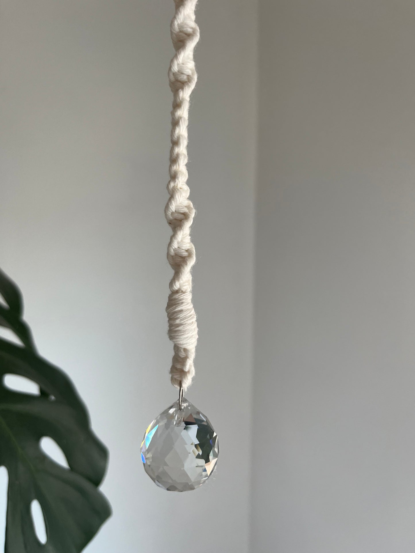 Macrame hanging sun catcher decoration with a crystal prism, made with natural coloured recycled cotton