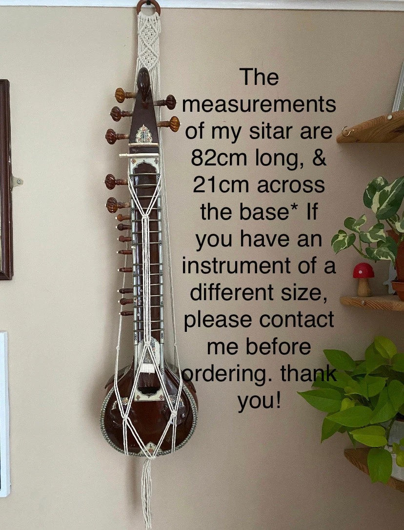 Mini sitar instrument wall hanger. Handmade using natural recycled cotton on a repurposed wooden hanging ring. Text on the screen gives the measurements of the instrument.