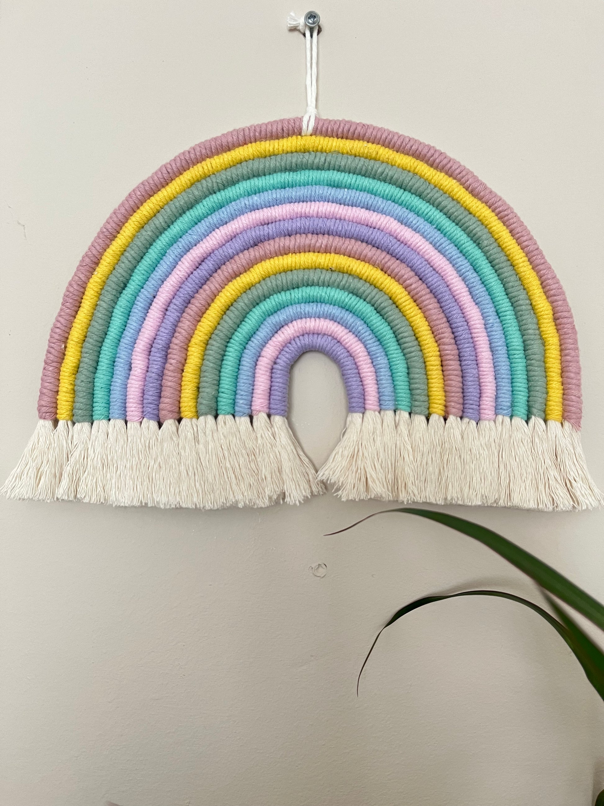 A large handmade macrame rainbow made with recycled cotton