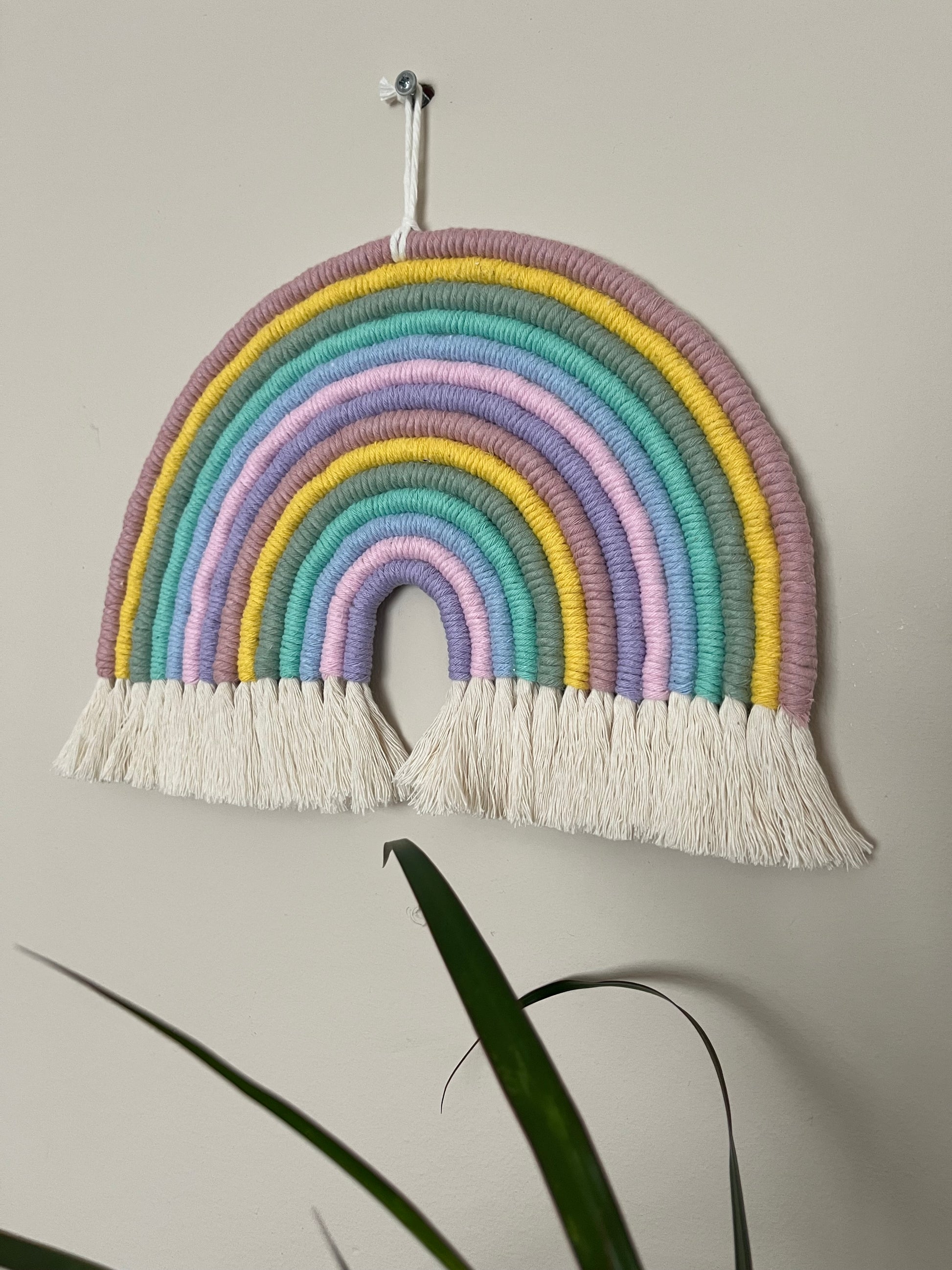 Handmade macrame rainbow wall hanging, made with pastel shades of recycled cotton