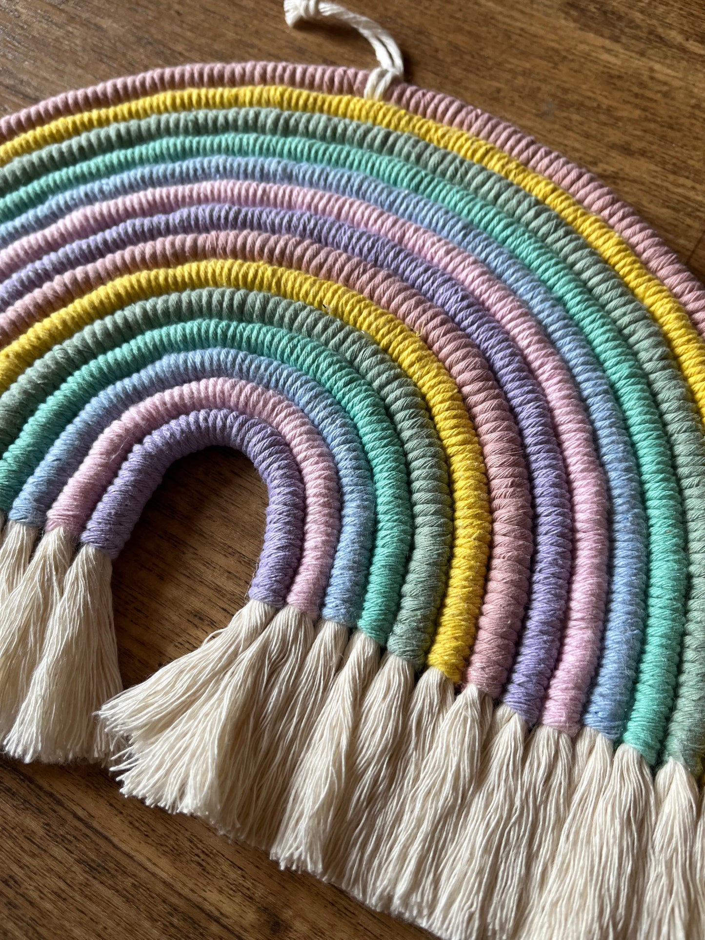 Close up of handmade macrame rainbow, made with recycled cotton