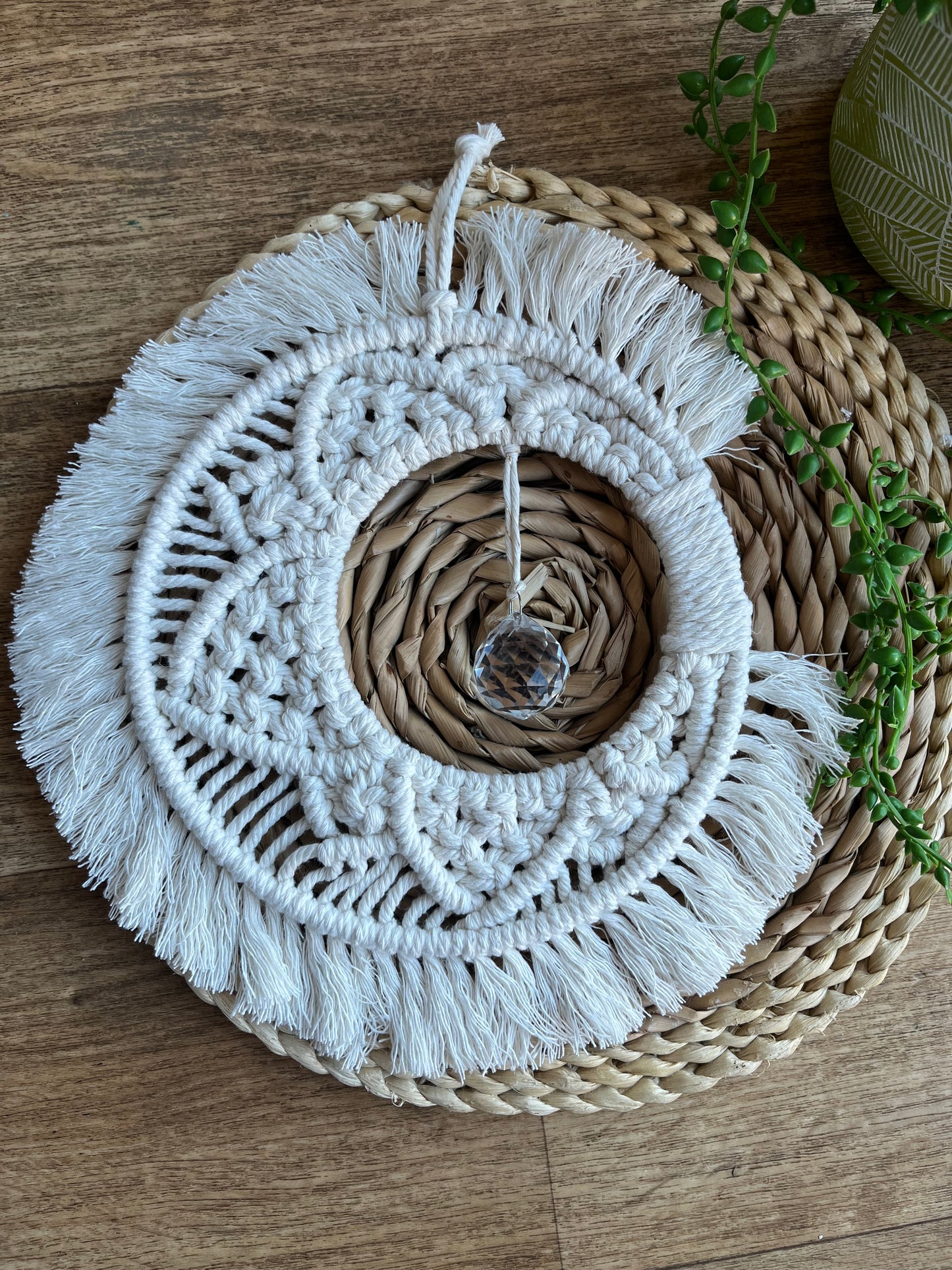 Handmade macrame moon shaped boho sun catcher made with recycled cotton natural yarn and a crystal prism in the centre.