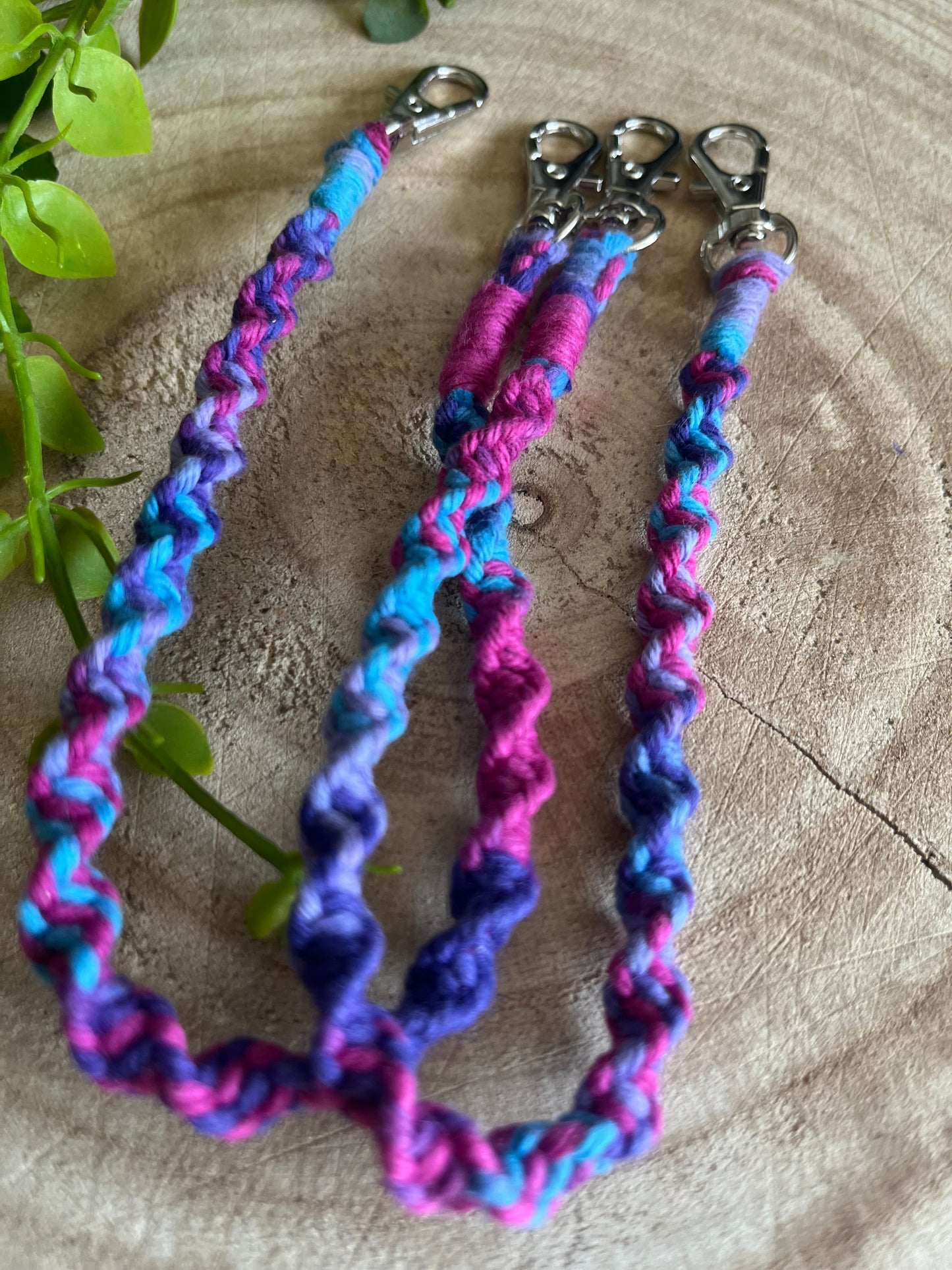 A pair of handmade boot chains, made with purple recycled cotton, and metal clasps on each end.