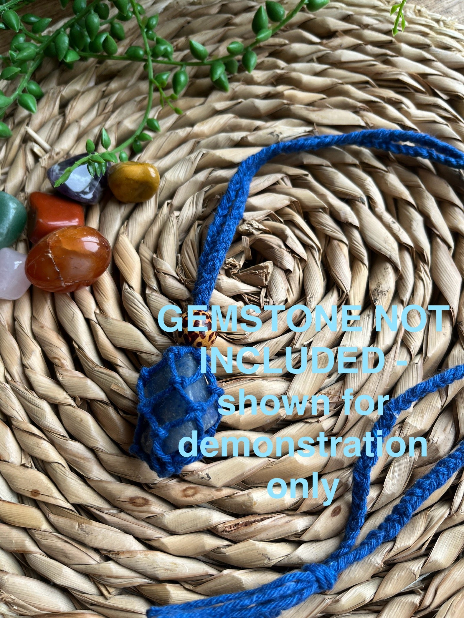 Macrame Gemstone Holder net pouch with blue gemstone inside, made with blue eco friendly recycled cotton and a Wooden bead. Blue text on the image explaining the gemstone is not included.