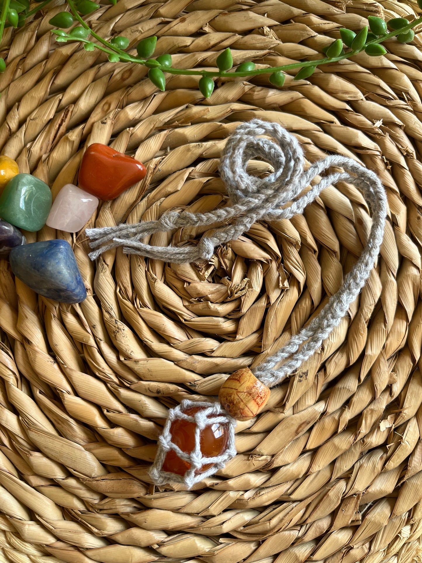Macrame Gemstone Holder net pouch with orange gemstone inside, made with grey eco friendly recycled cotton and a Wooden bead.