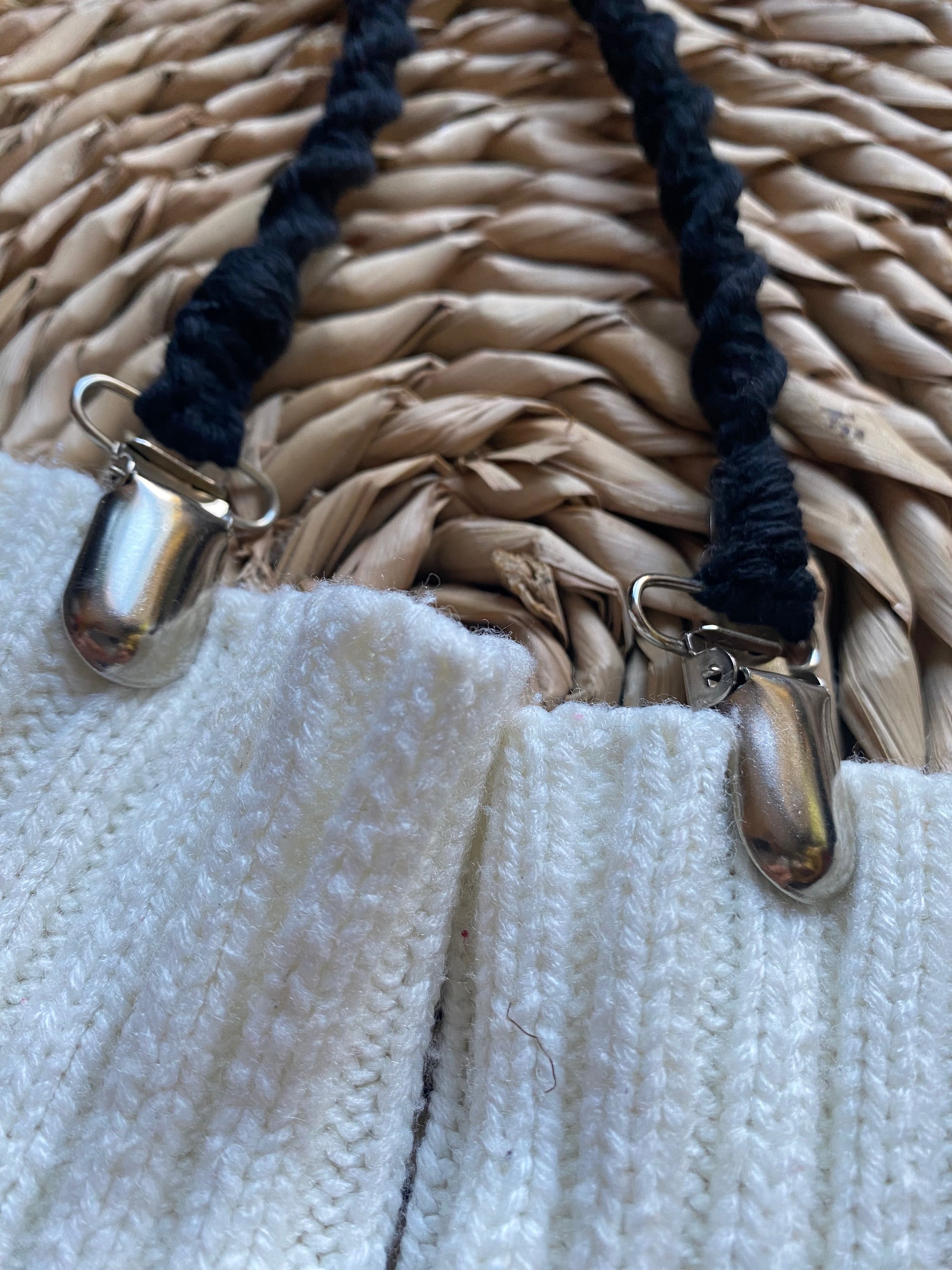 Close-up of secure metal clasps on black eco-friendly long mitten clips, attached to white mittens - handmade with recycled materials by Macra-Made With Love