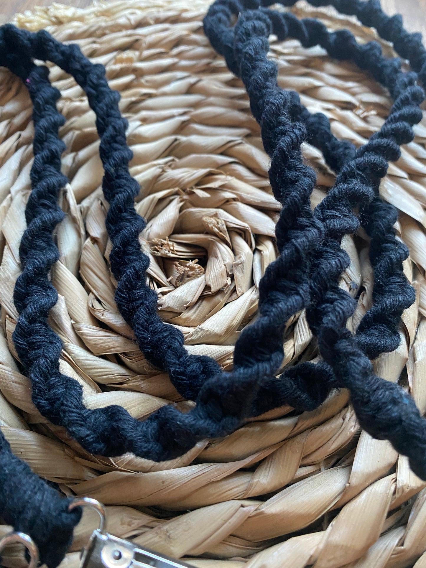 Close-up of handcrafted knots on black recycled cotton long mitten clips - showing quality craftsmanship and sustainable materials