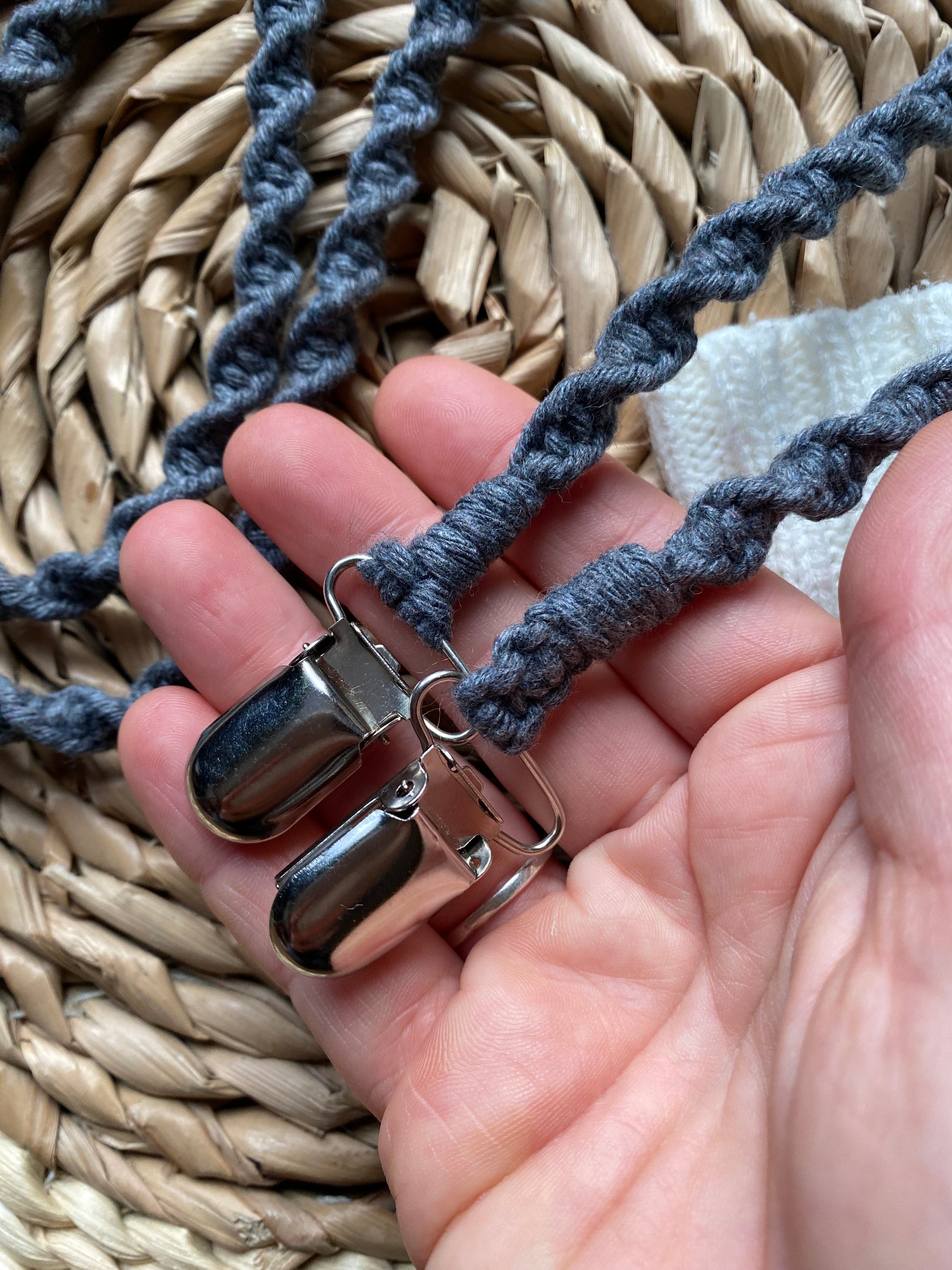 Grey eco-friendly long mitten clips held in hand showing metal clasps - handmade 190cm winter accessory made with recycled materials