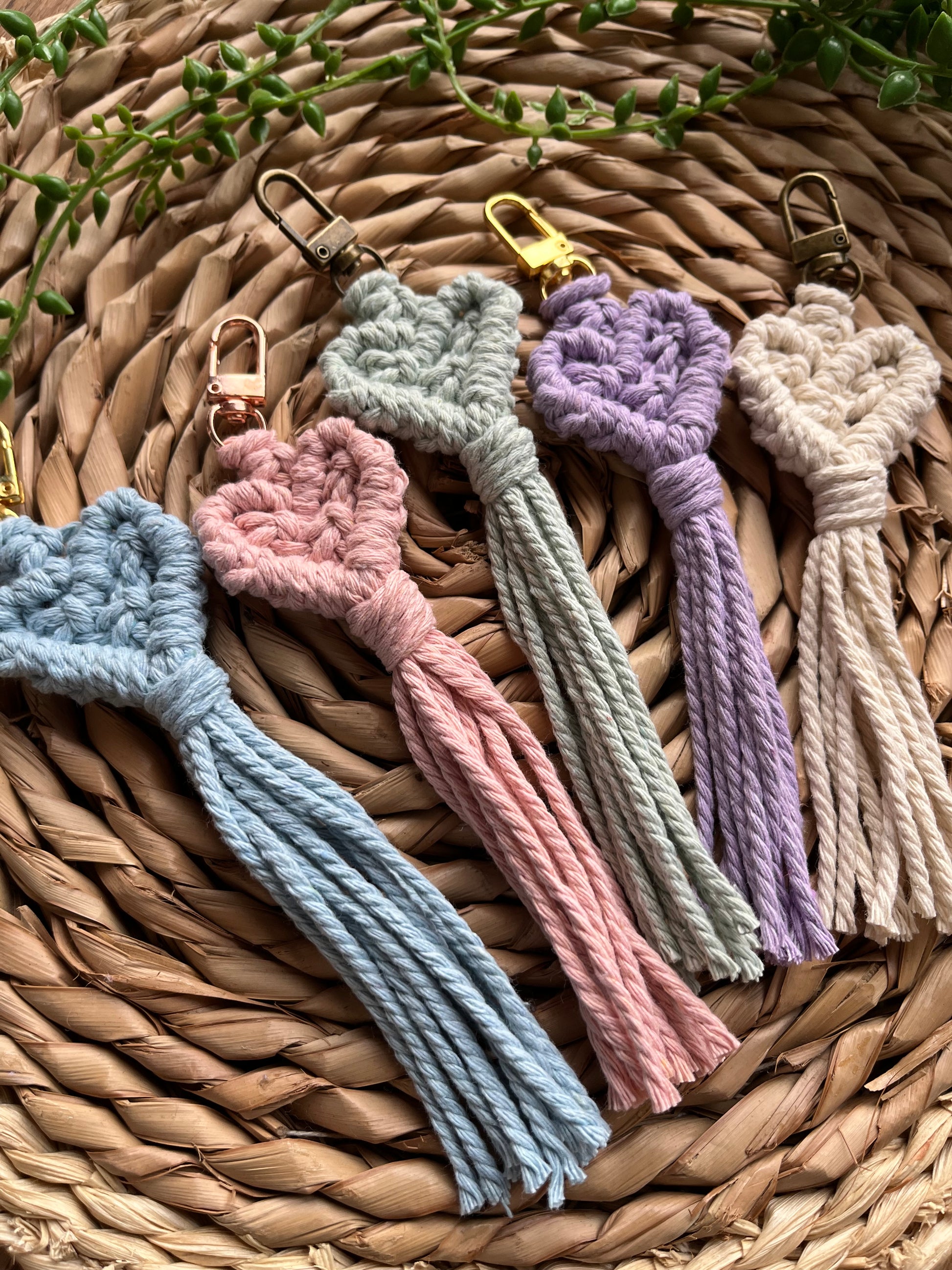 five handmade macrame heart shaped keychains, made with recycled cotton in a variety of pastel shades