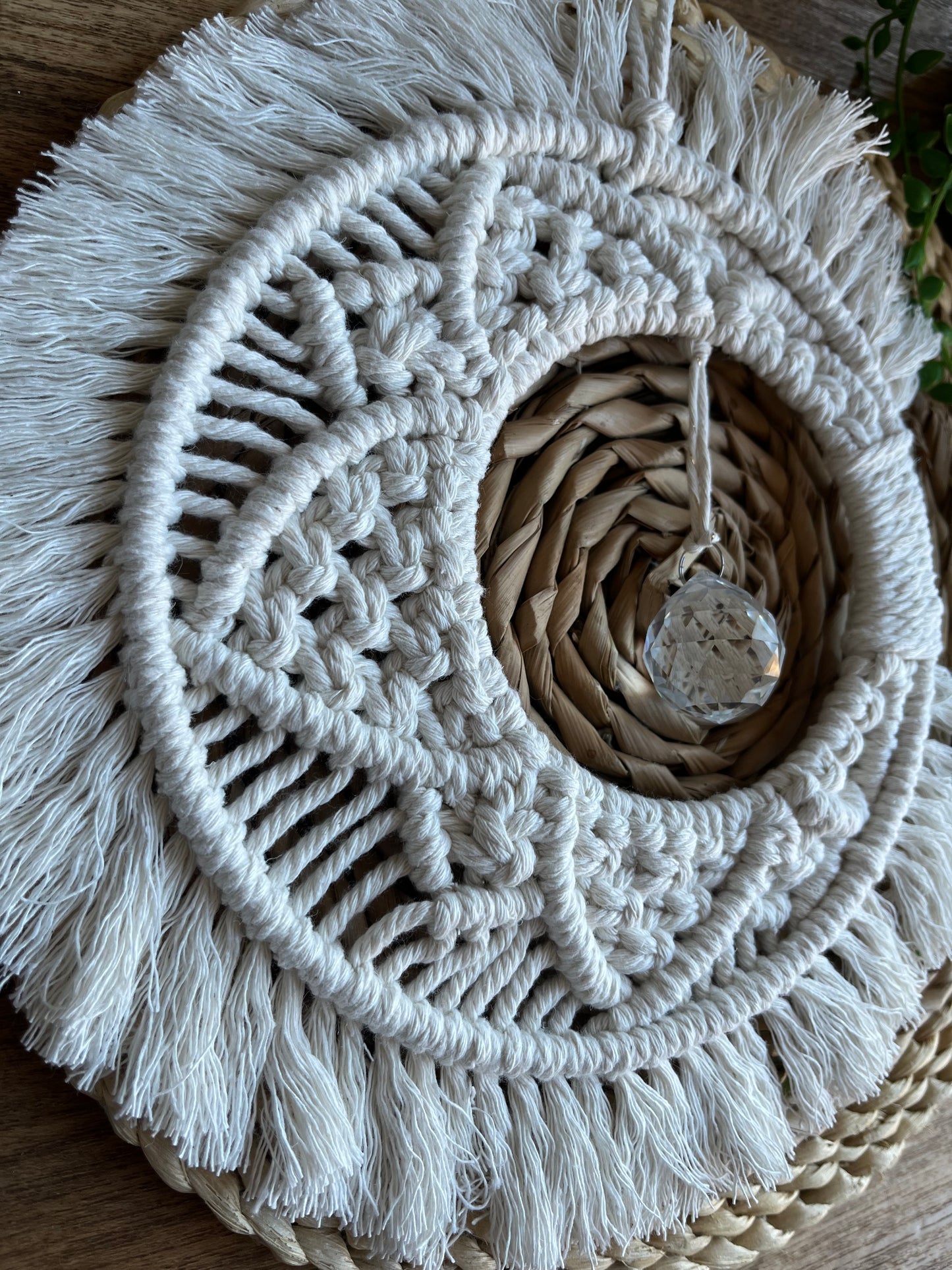 Handmade macrame moon shaped boho sun catcher made with recycled cotton natural yarn and a crystal prism in the centre.