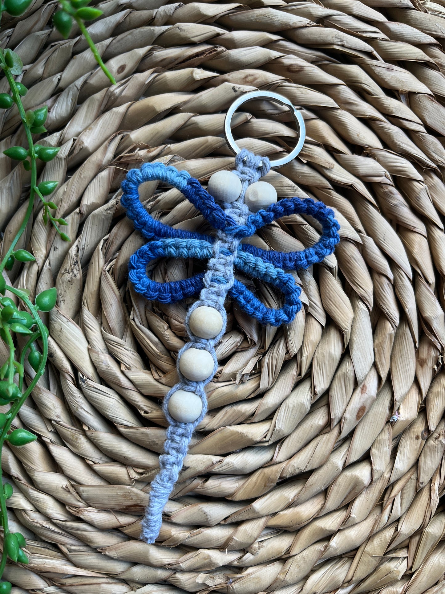 Handmade macrame dragonfly keyring or bag charm, made using shades of blue recycled cotton, on a metal split ring, with small wooden beads.
