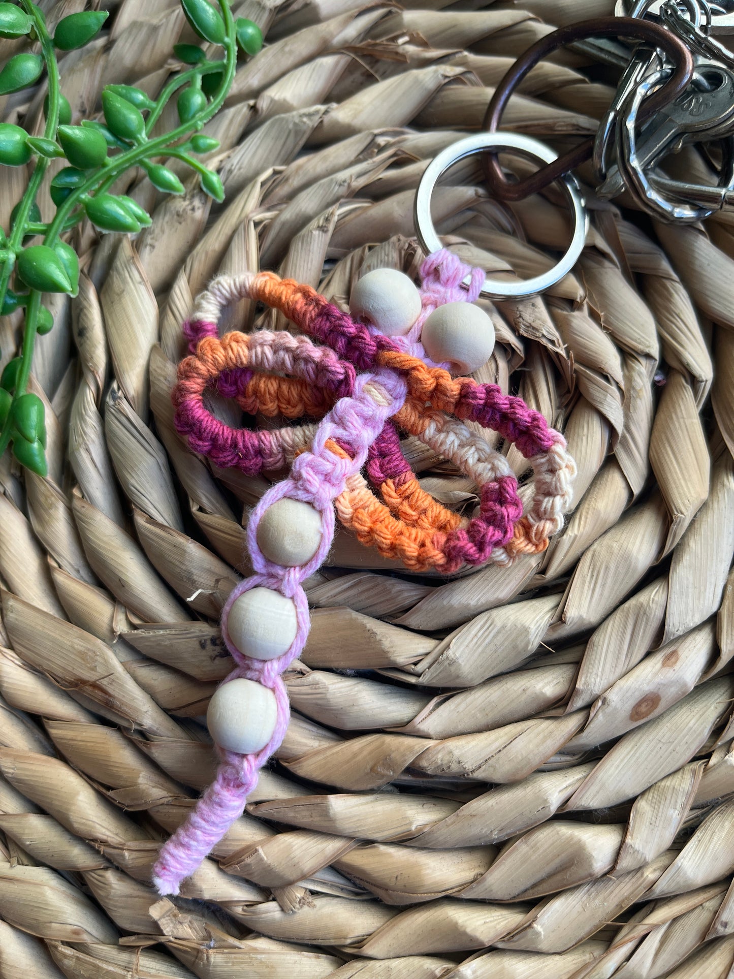 Handmade macrame dragonfly keyring or bag charm, made using shades of pink recycled cotton, on a metal split ring, with small wooden beads.