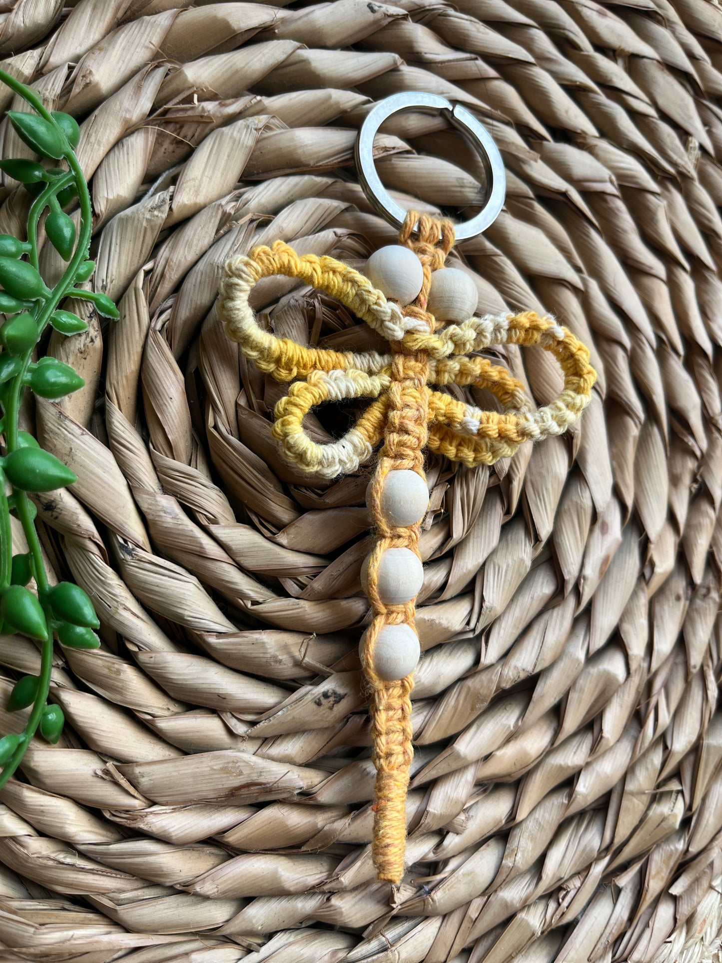 Handmade macrame dragonfly keyring or bag charm, made using shades of yellow recycled cotton, on a metal split ring, with small wooden beads.
