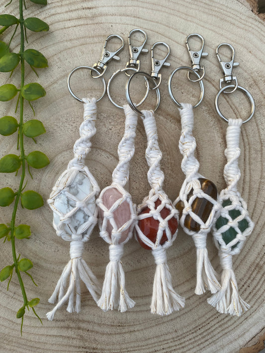 5 handmade macrame gemstone keyrings, made with natural coloured cotton yarn and metal split ring clasps, each with a different gemstone held in the macrame knots.