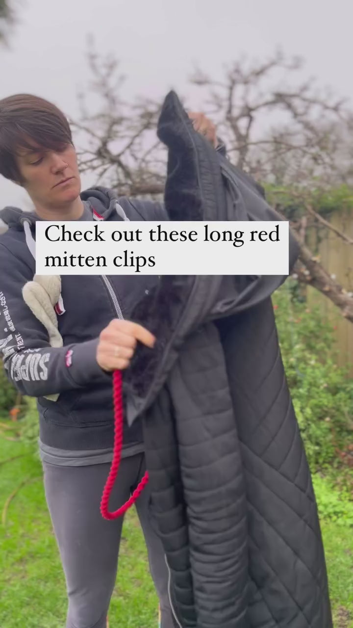 Video showing a woman standing outside, demonstrating how to use a set of macro-made with love handmade eco friendly long mitten holder clips.