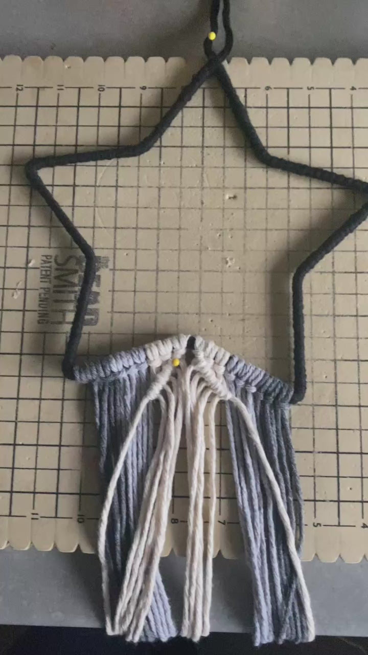 Video showing part of the making process of a star shaped macrame wall hanging.