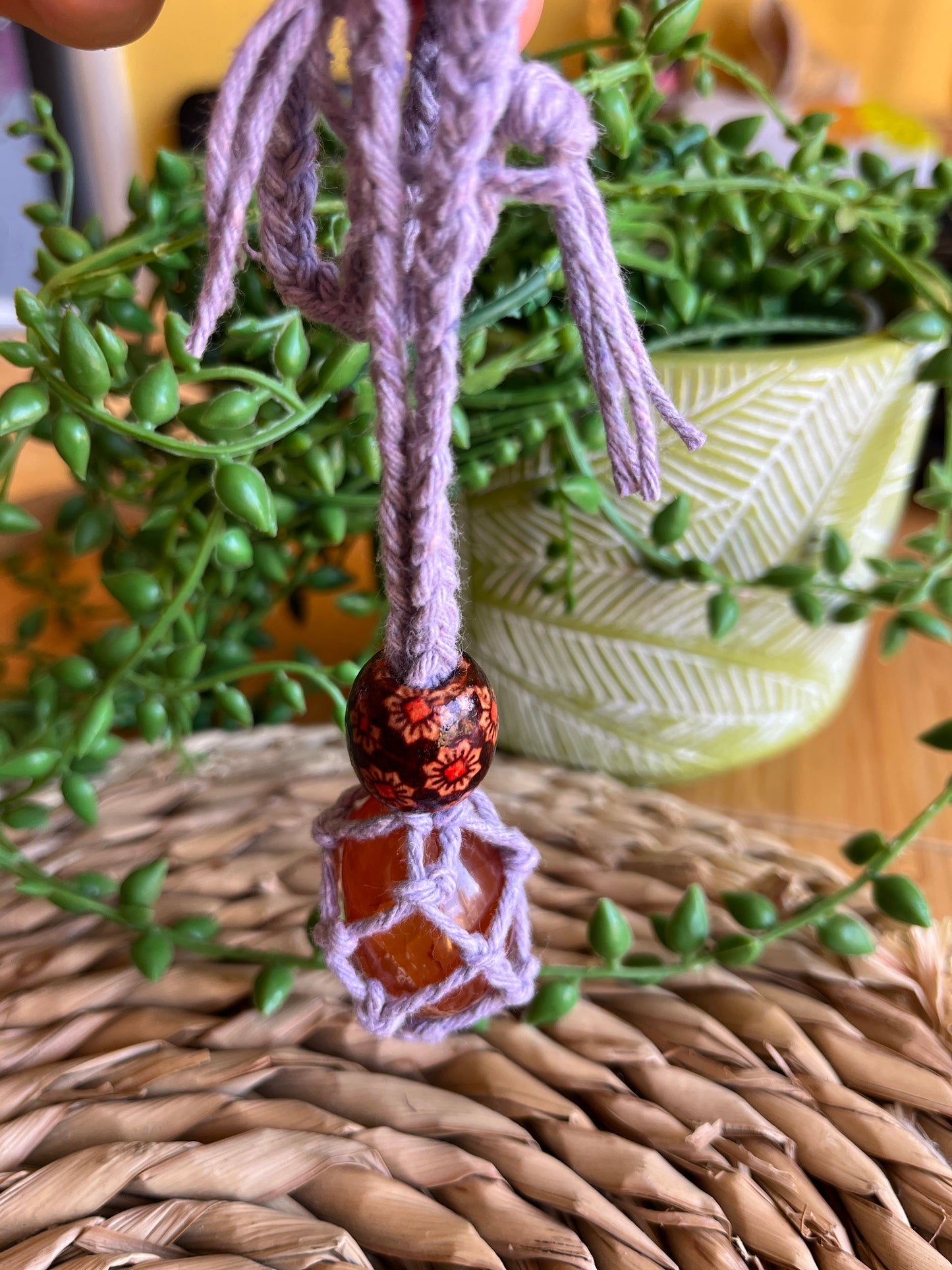 Macrame Gemstone Holder net pouch with blue gemstone inside, made with purple eco friendly recycled cotton and a Wooden bead.
