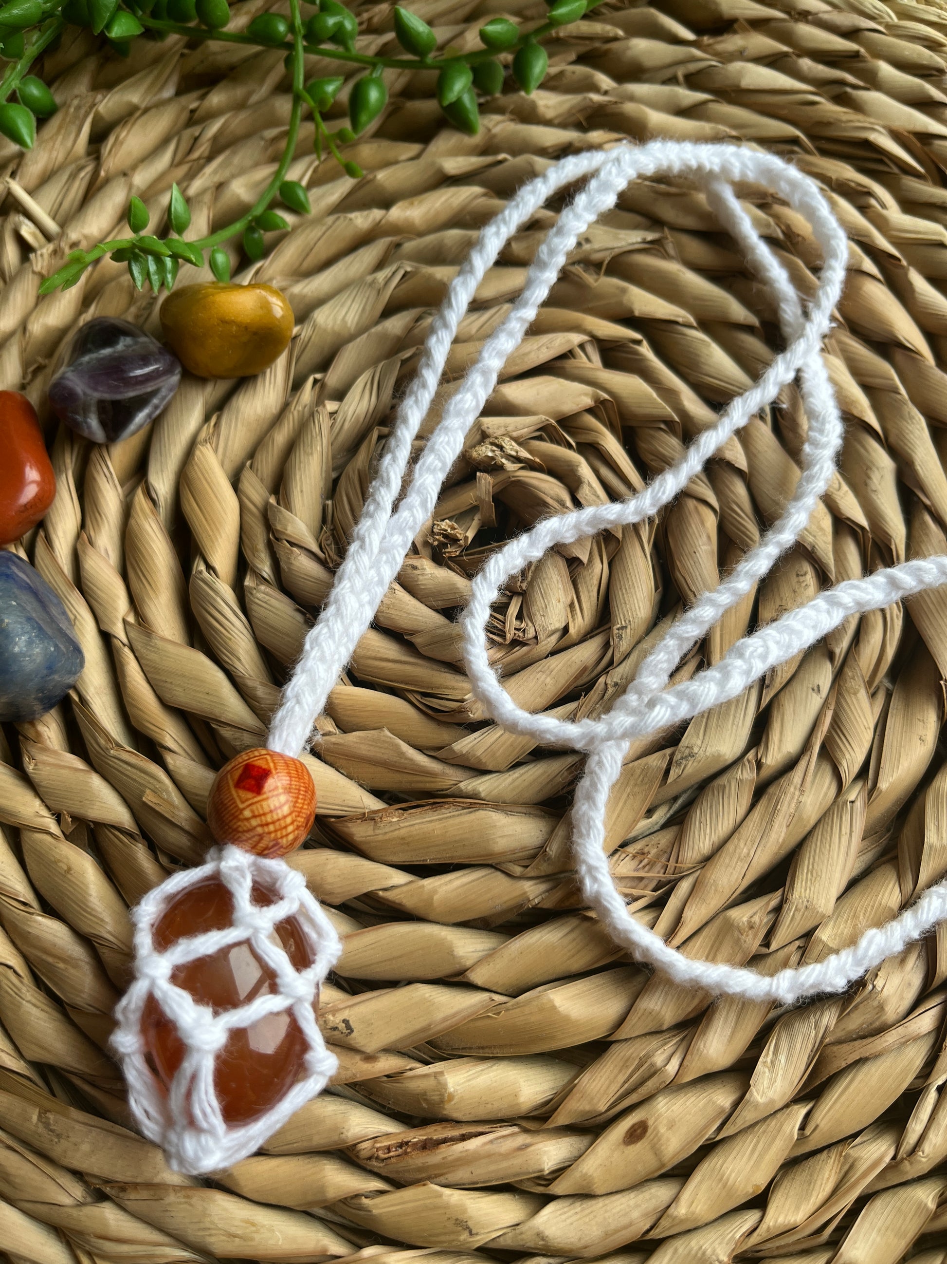 Macrame Gemstone Holder net pouch with orange gemstone inside made with white eco friendly recycled cotton and a Wooden bead