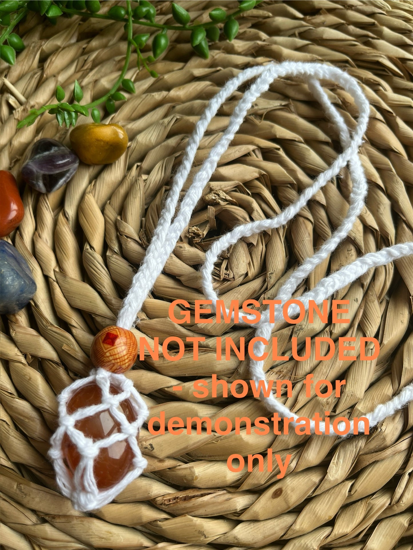 Macrame Gemstone Holder net pouch with orange gemstone inside, made with white eco friendly recycled cotton and a Wooden bead. Orange text on the image explaining the gemstone is not included.