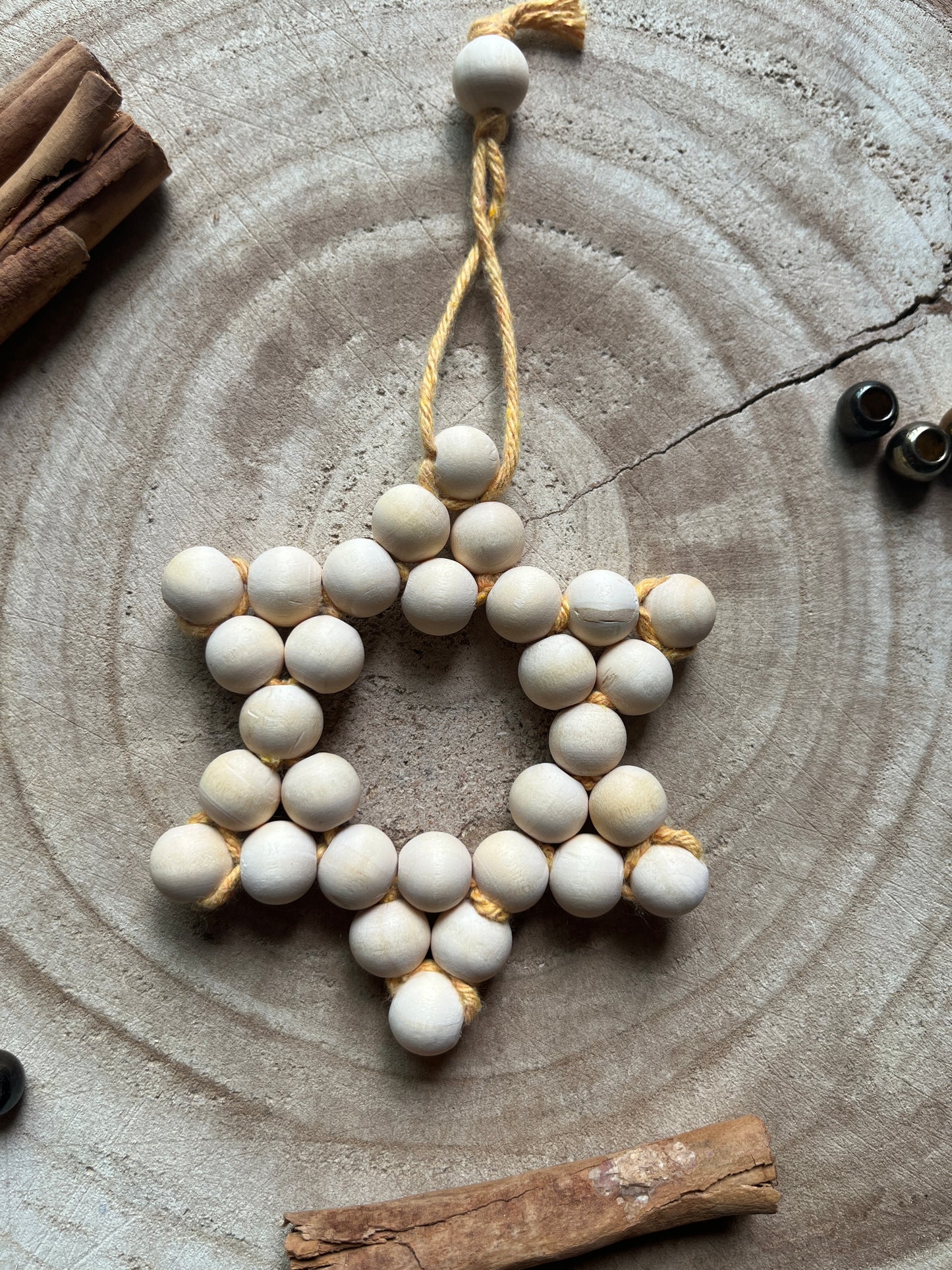 Decorative star made of wooden beads on a rustic wooden surface