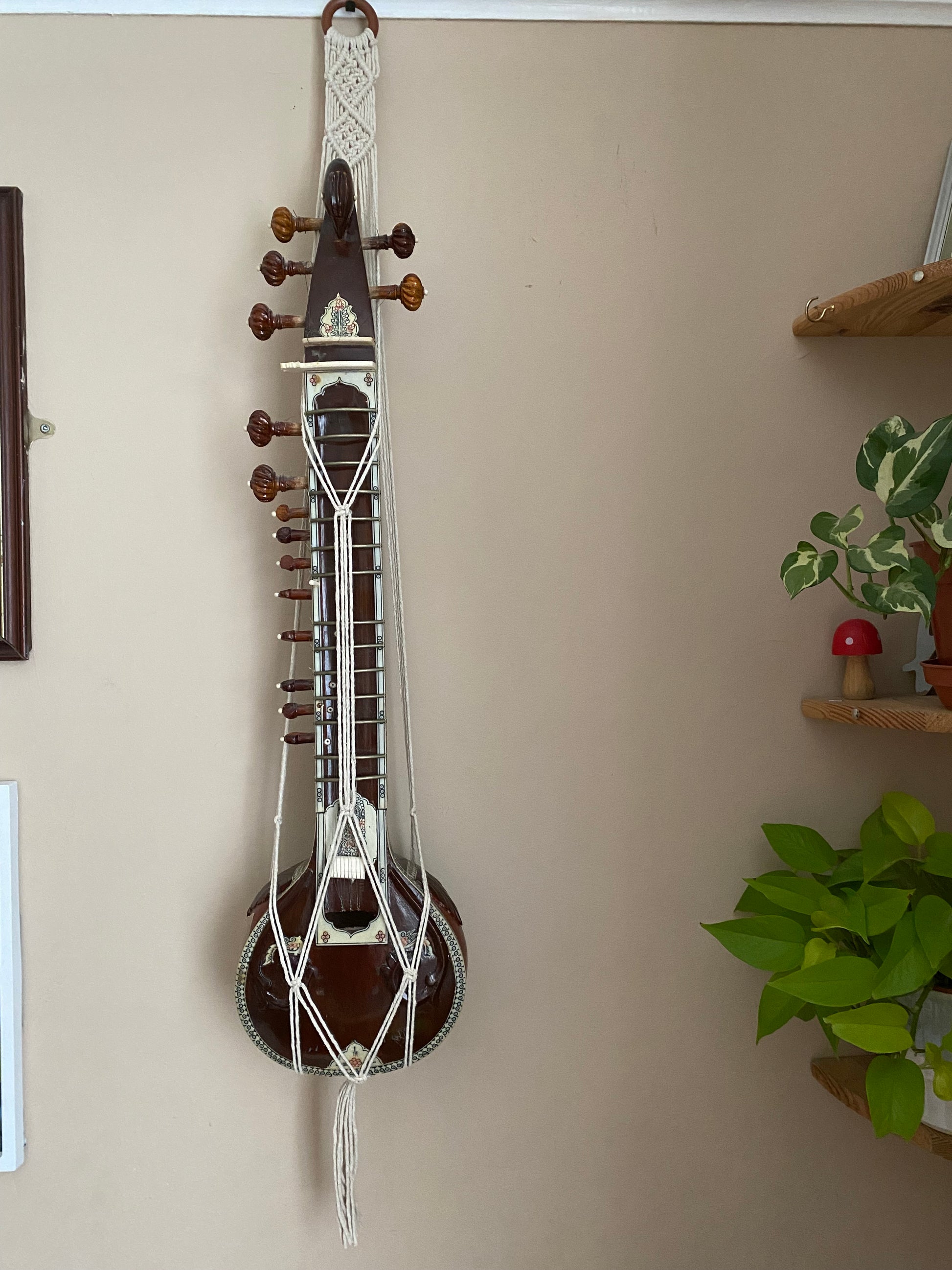 Mini sitar instrument wall hanger. Handmade using natural recycled cotton on a repurposed wooden hanging ring.