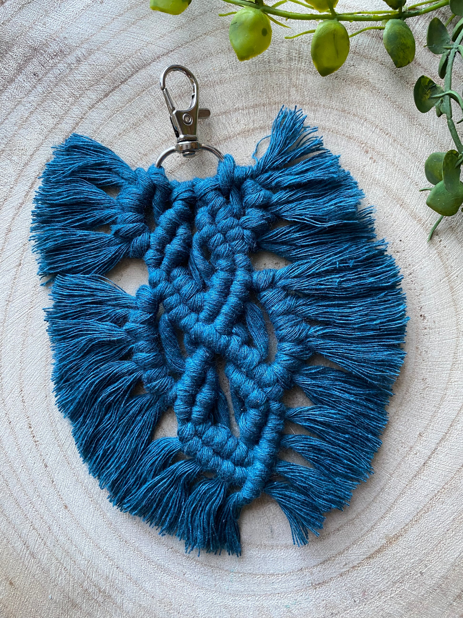Handmade macrame feather shaped keyring, made with peacock blue recycled cotton and a small metal clasp.