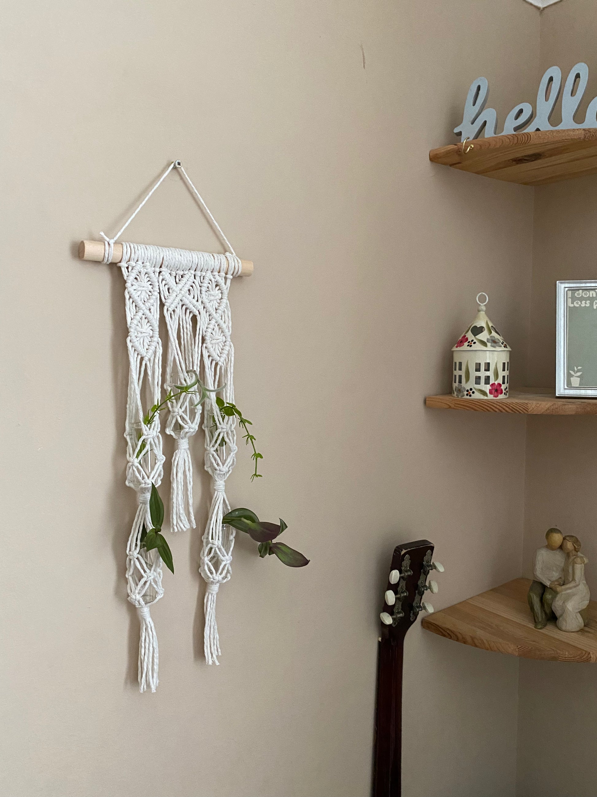 Macra-Made With Love Macrame wall hanger houseplant propagation station made with natural yarn on a wooden dowel, against a beige wall.