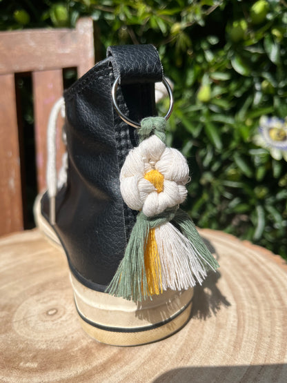 Handmade macrame daisy boot charm, made with recycled cotton, attached to a pair of black hi top boots with a metal split ring