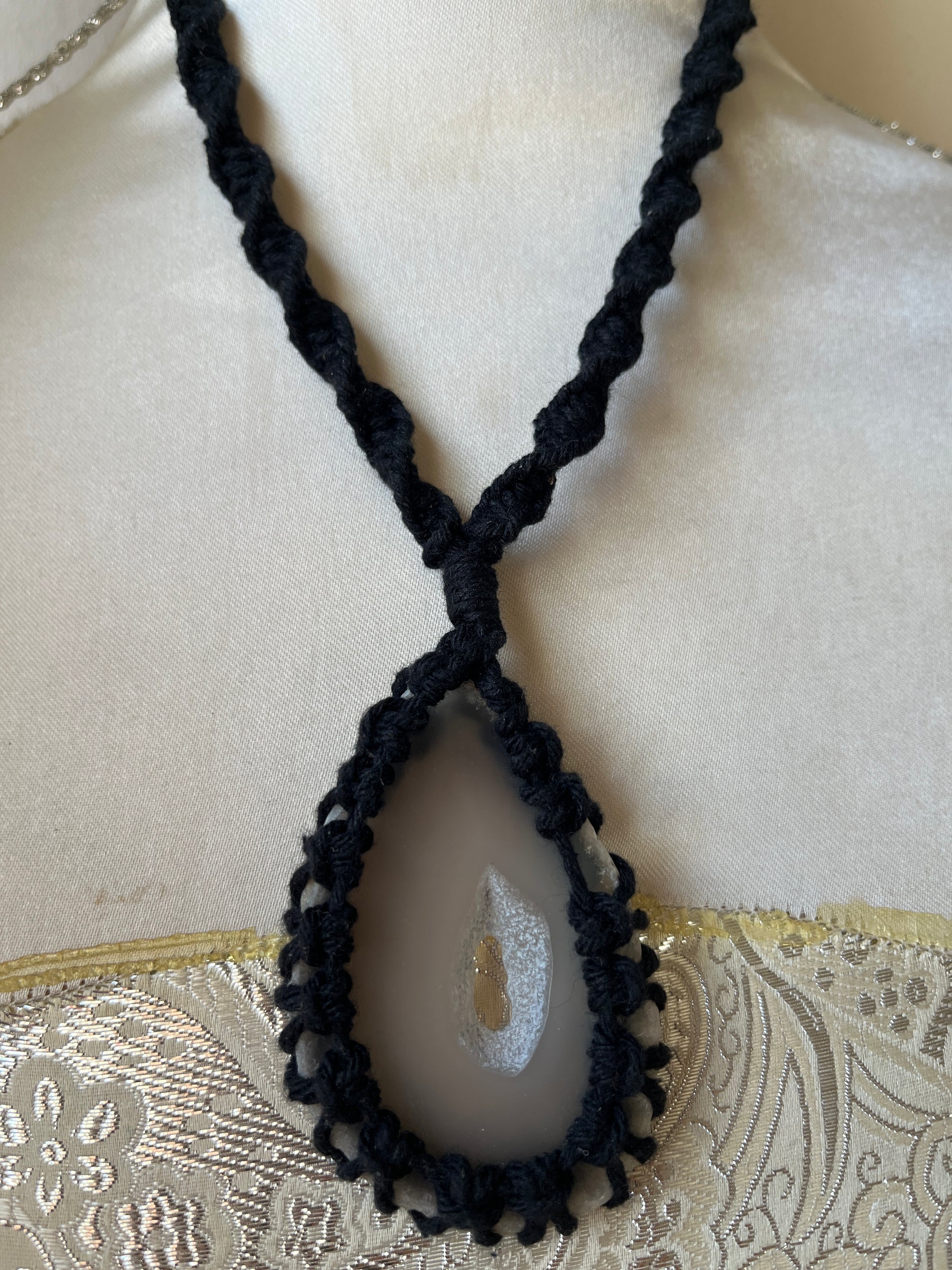 Close up image of Black necklace with natural agate slice on a mannequin 