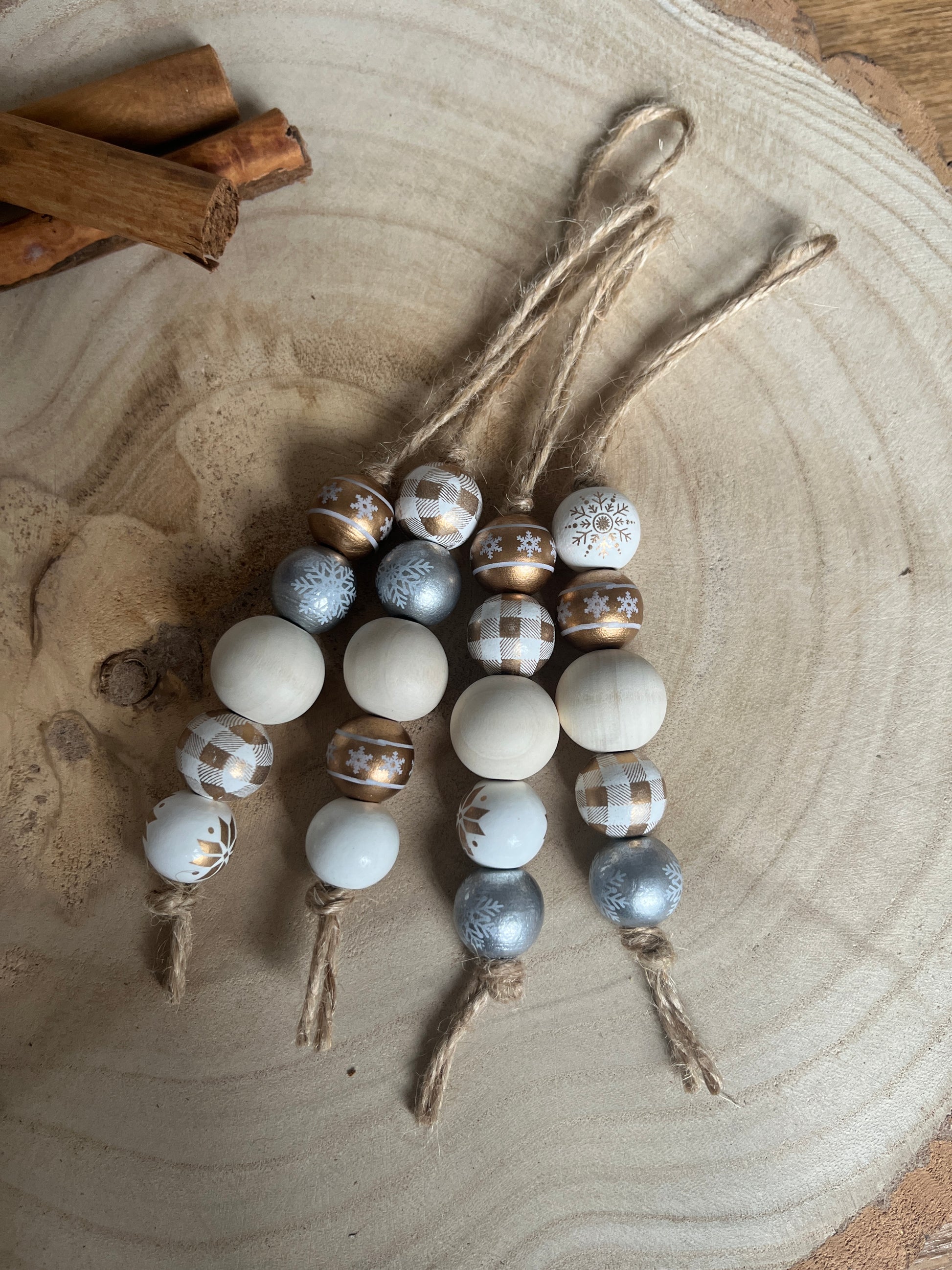 Decorative beads on a wooden surface with cinnamon sticks