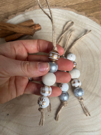 Hand holding a decorative bead ornament with a wooden background