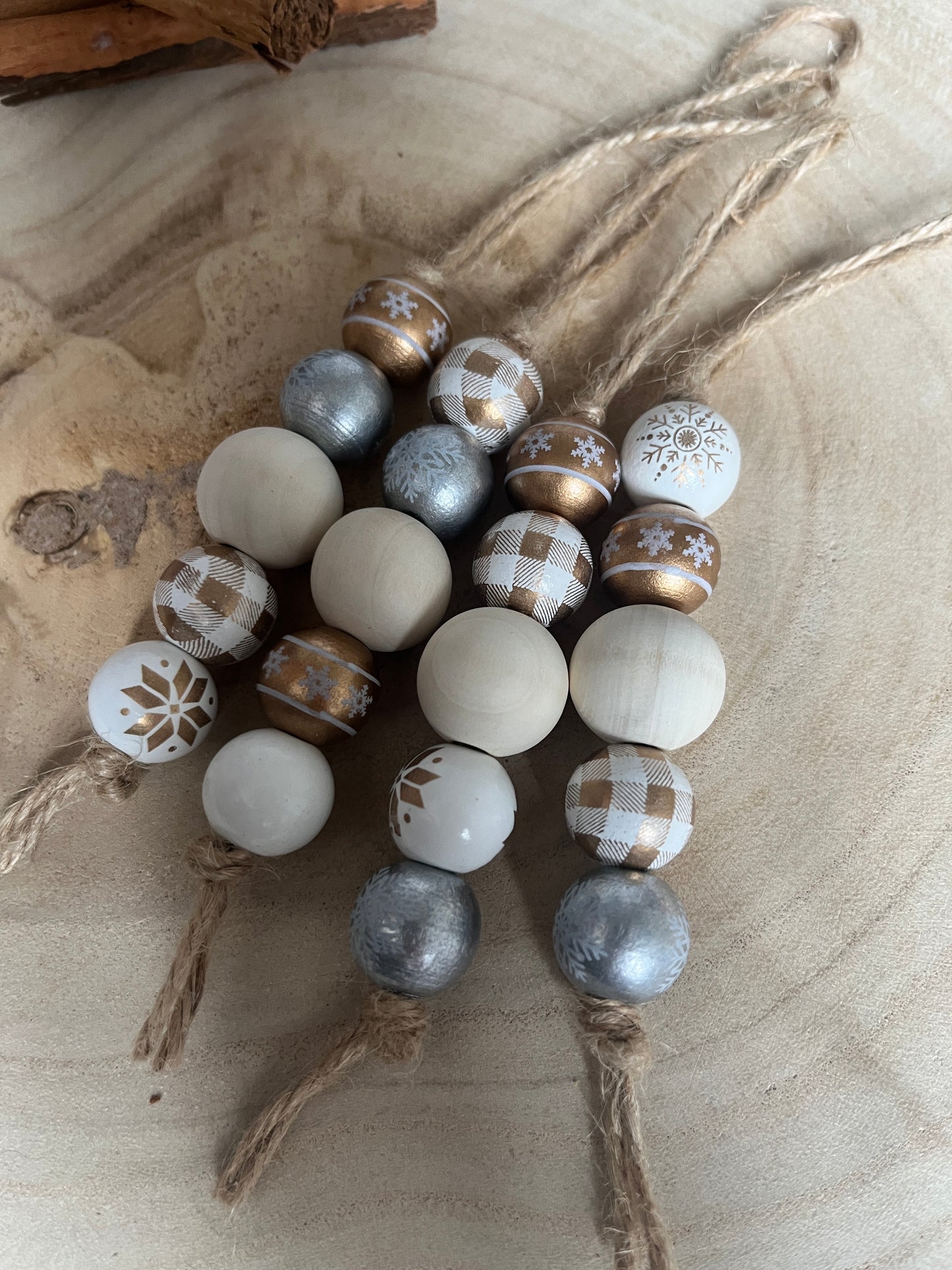 Decorative beads with festive patterns on a beige wooden background