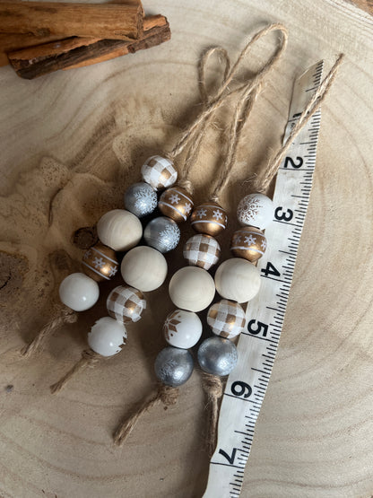 Decorative string of multicolored beads on a wooden surface with a ruler for scale.