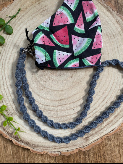 Handmade macramé face mask lanyard in dark grey cotton cord attached by small metal clips on to a face mask which has a watermelon print.