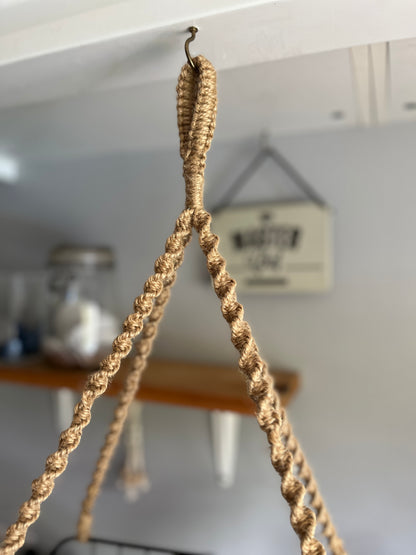 Close-up of a jute rope hanging from a hook with a blurred background