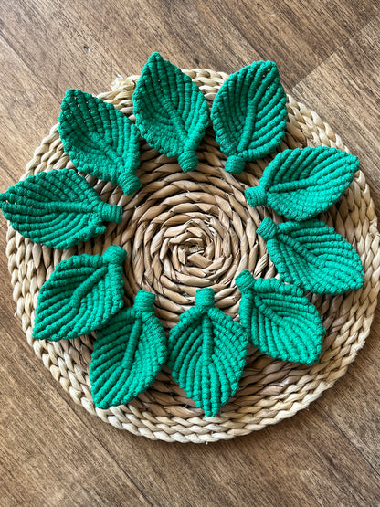 10 green macrame leaf embellishments on a round woven mat. 