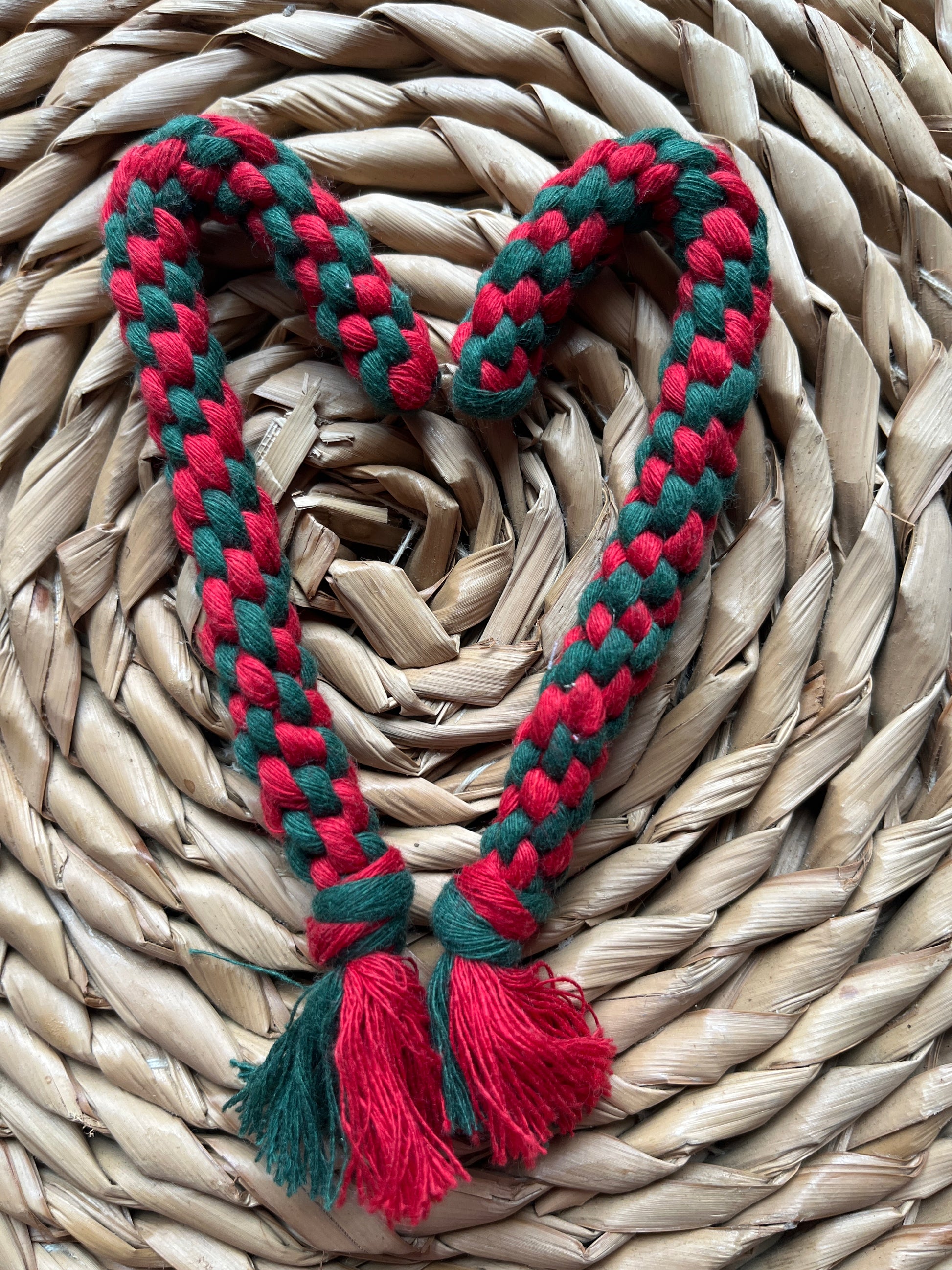 Red and green braided candy canes on a woven surface