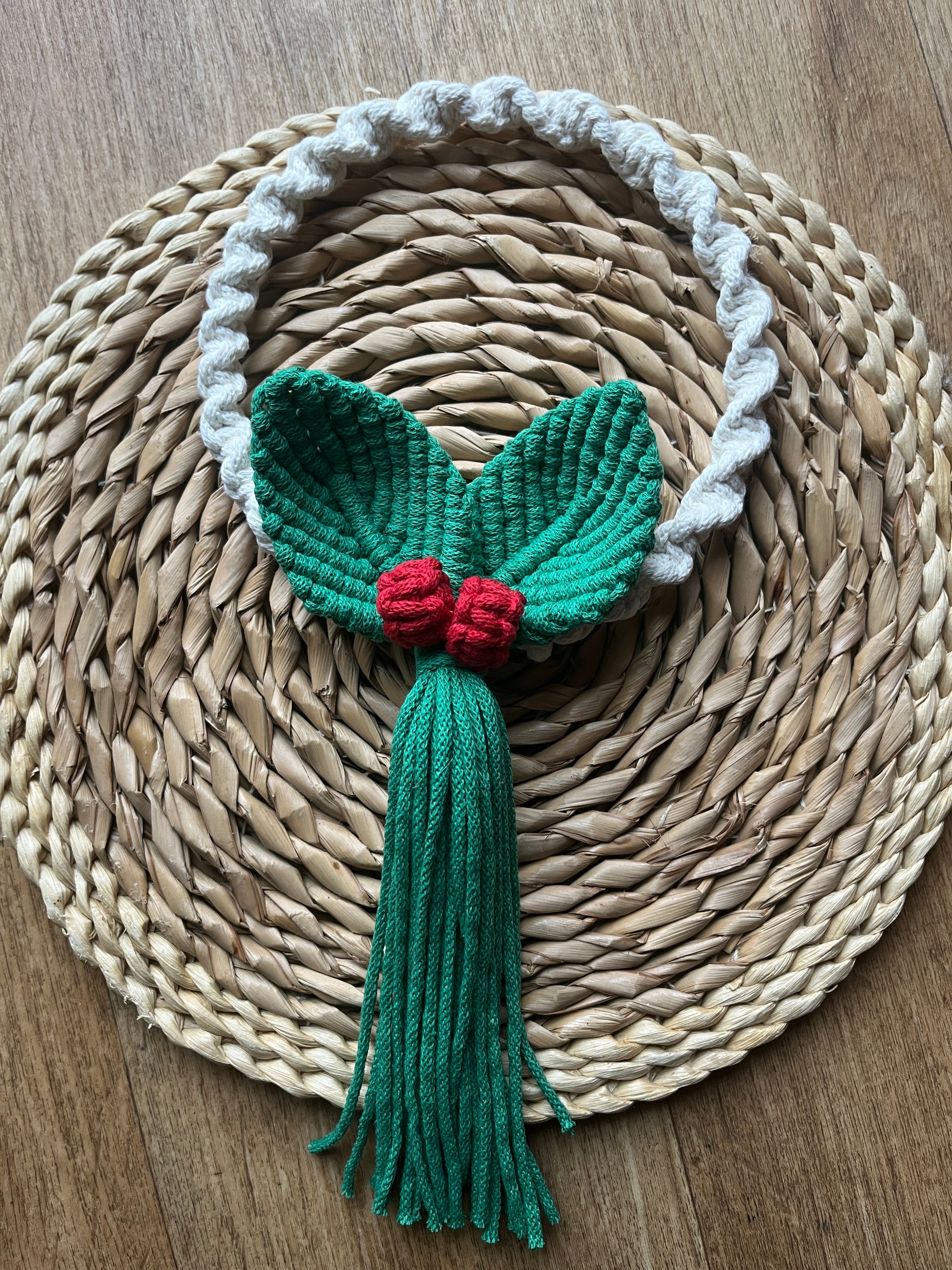 Handmade macrame wreath with green leaves and red berries