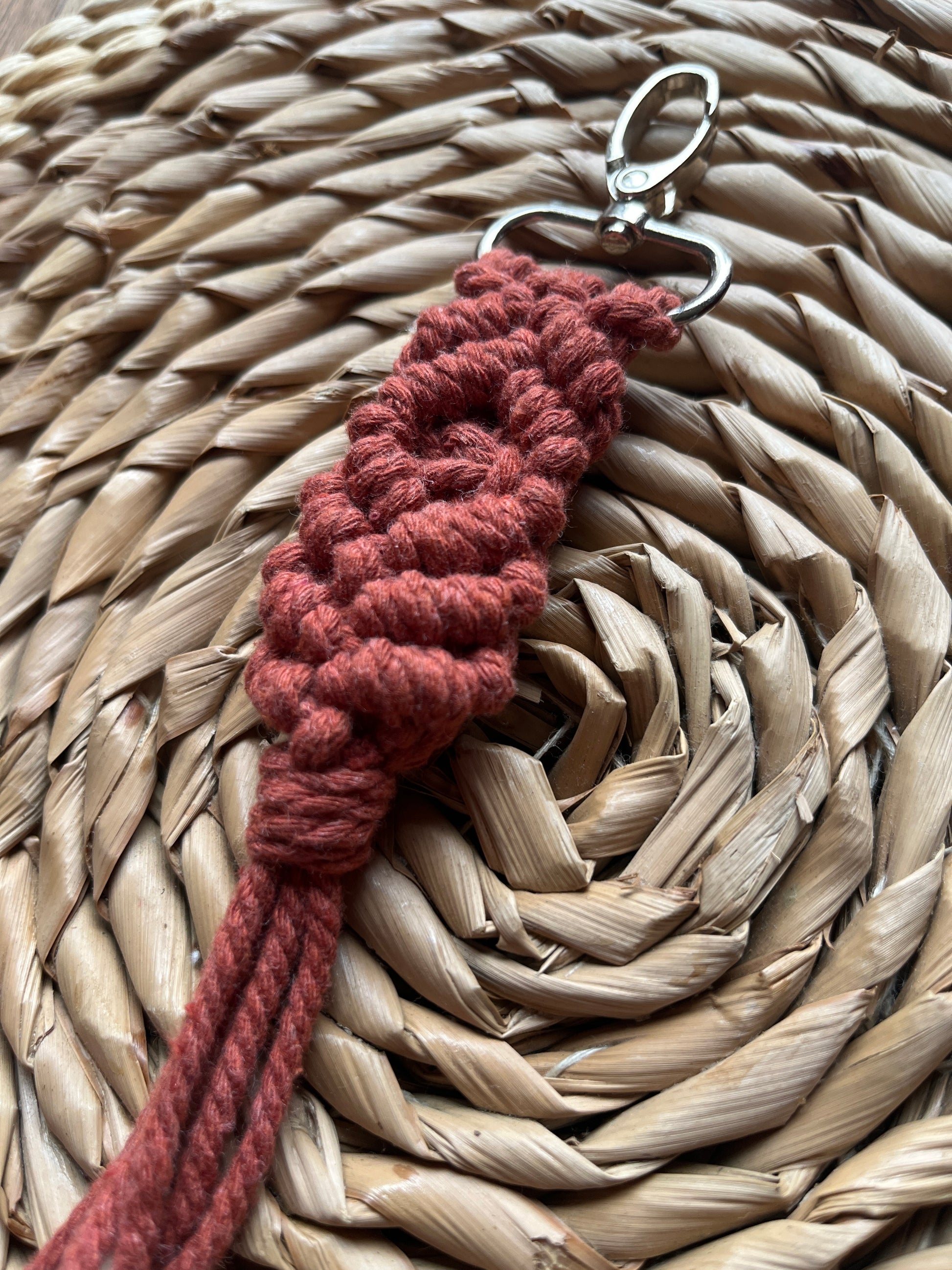 Red braided keychain on a woven surface